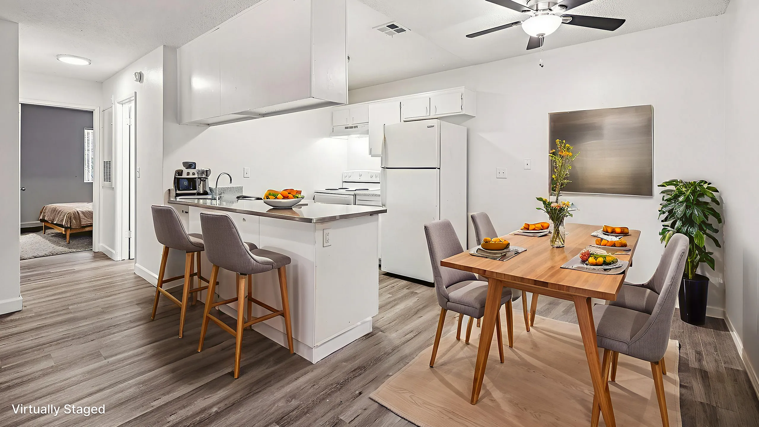 Bright, virtually staged apartment showcasing an open-concept kitchen with sleek white cabinets, a cozy dining area with modern seating, and a stylish living space perfect for relaxation.
