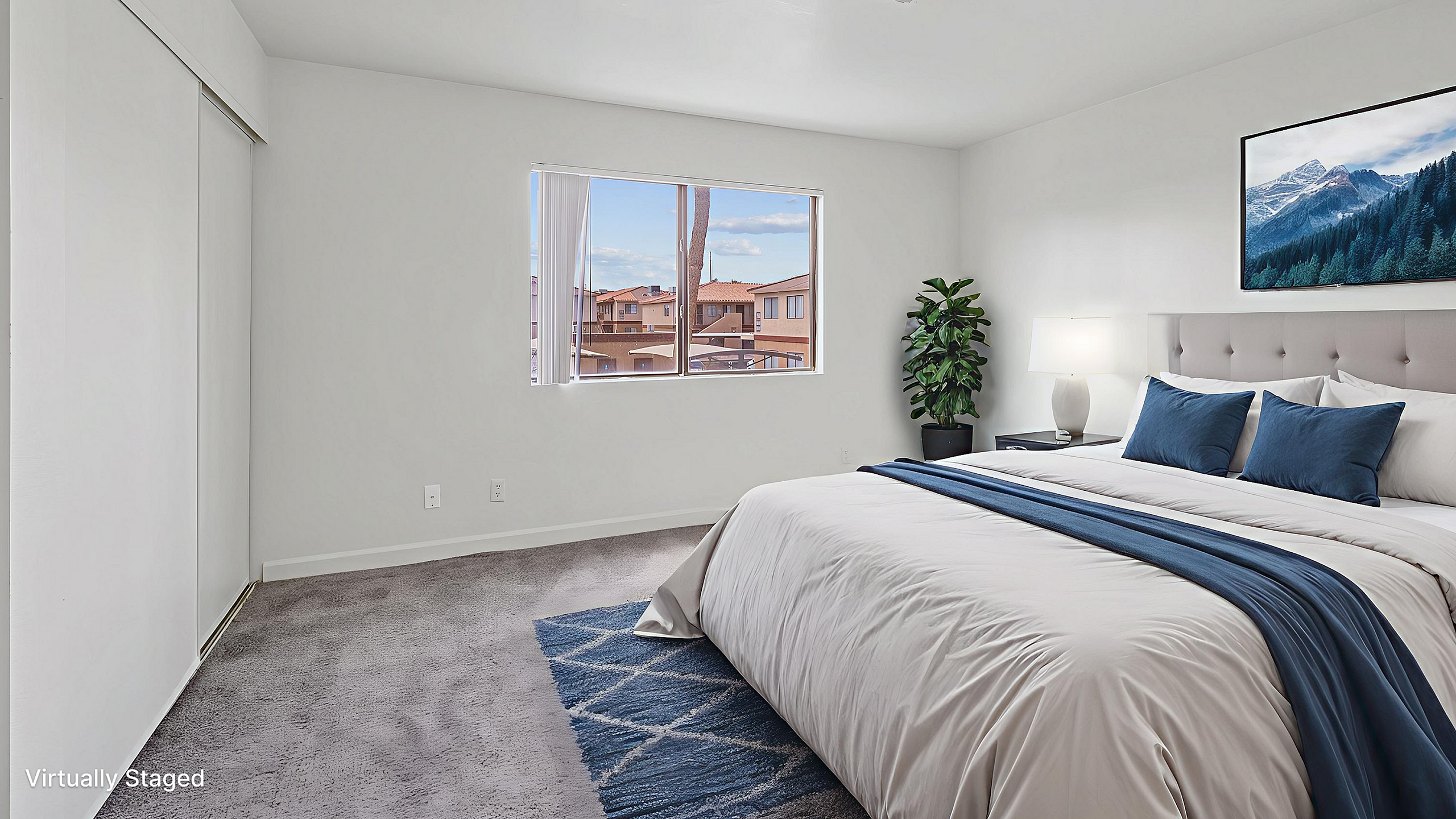 Inviting bedroom with large window view, stylish decor, and cozy bedding offers serene comfort and natural lighting.