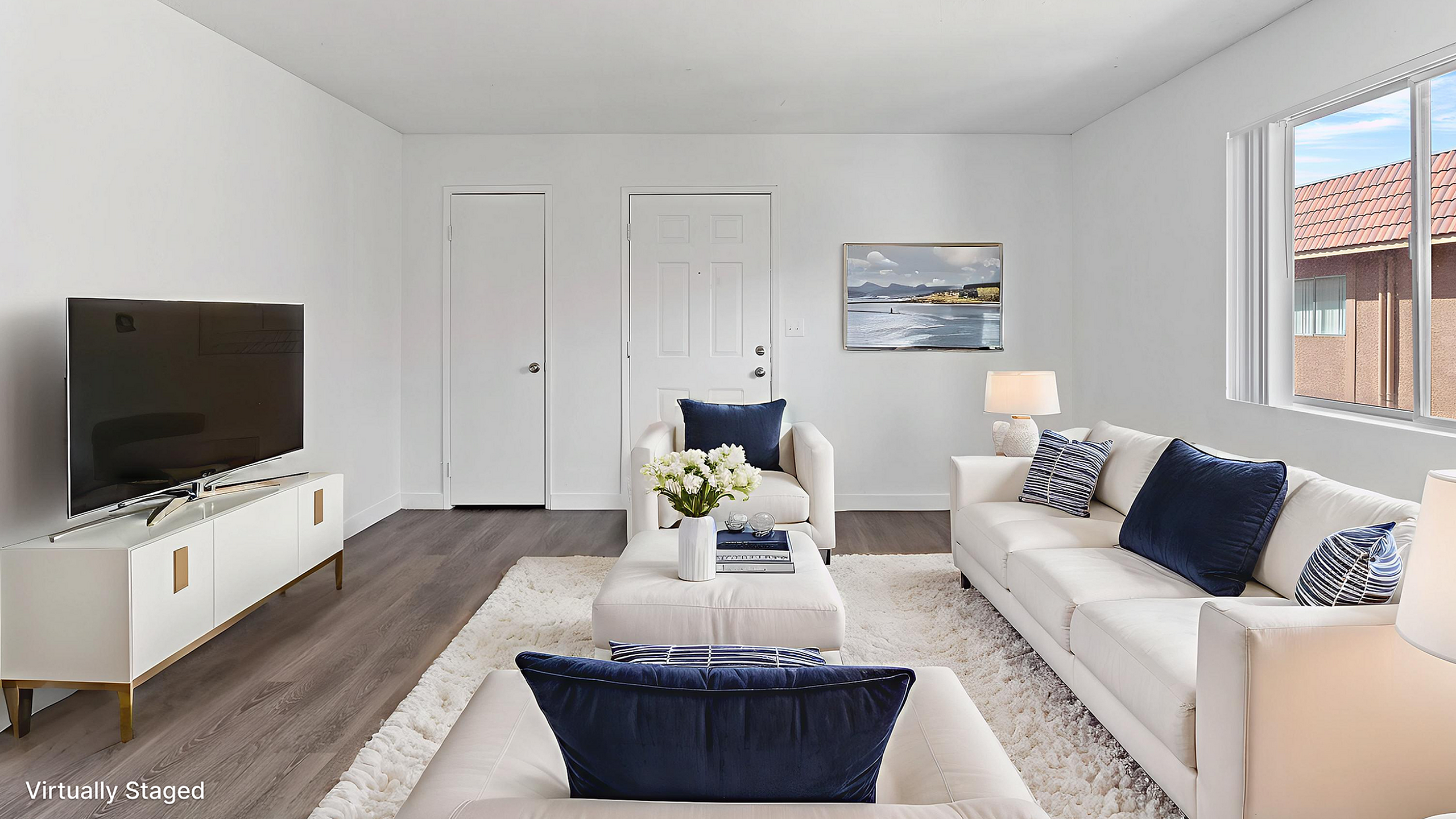 Bright, virtually staged living room with chic white furniture, stylish navy accents, and ample natural light.