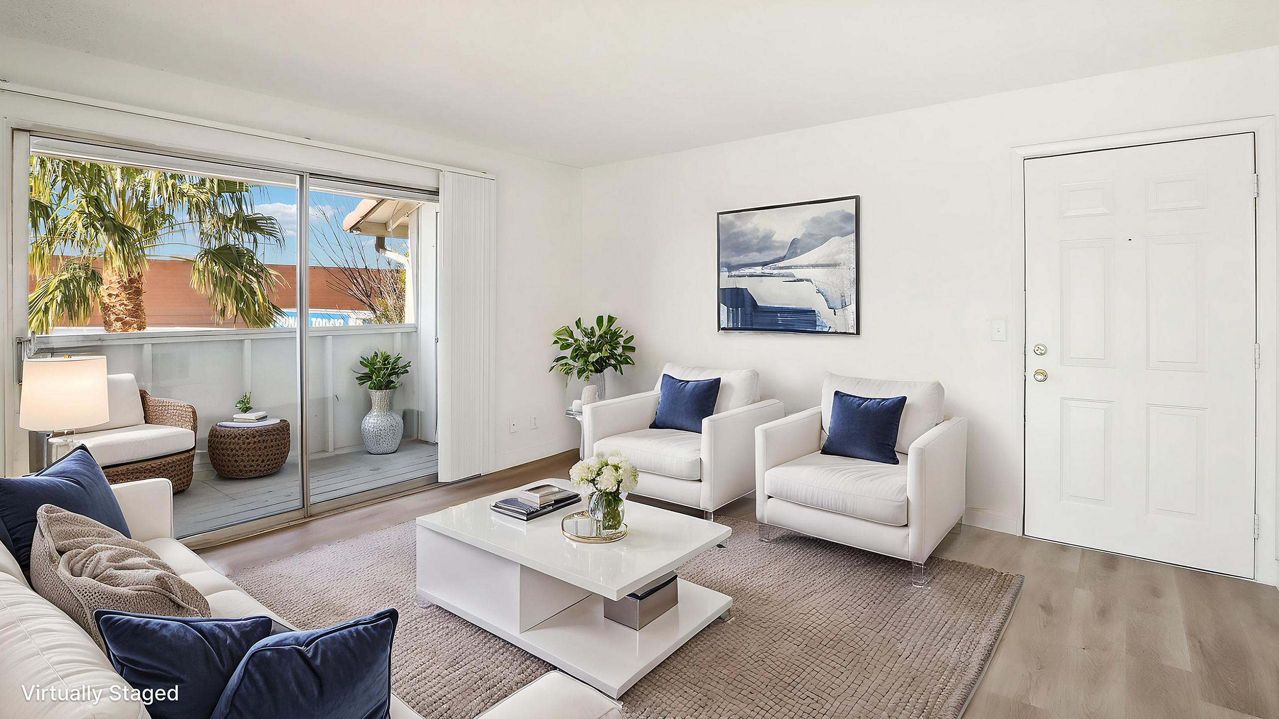 Bright and inviting living room with modern furniture, stylish decor, and a view of lush palm trees through sliding glass doors.