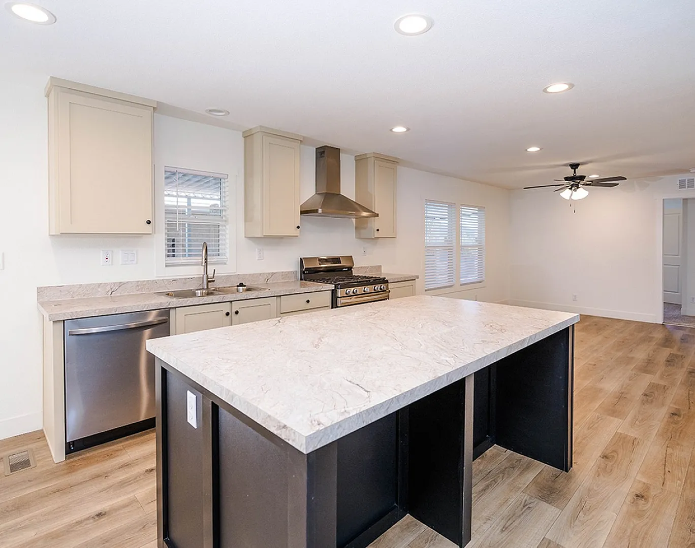 Modern kitchen with elegant marble countertops, stainless steel appliances, and beautiful wood flooring.