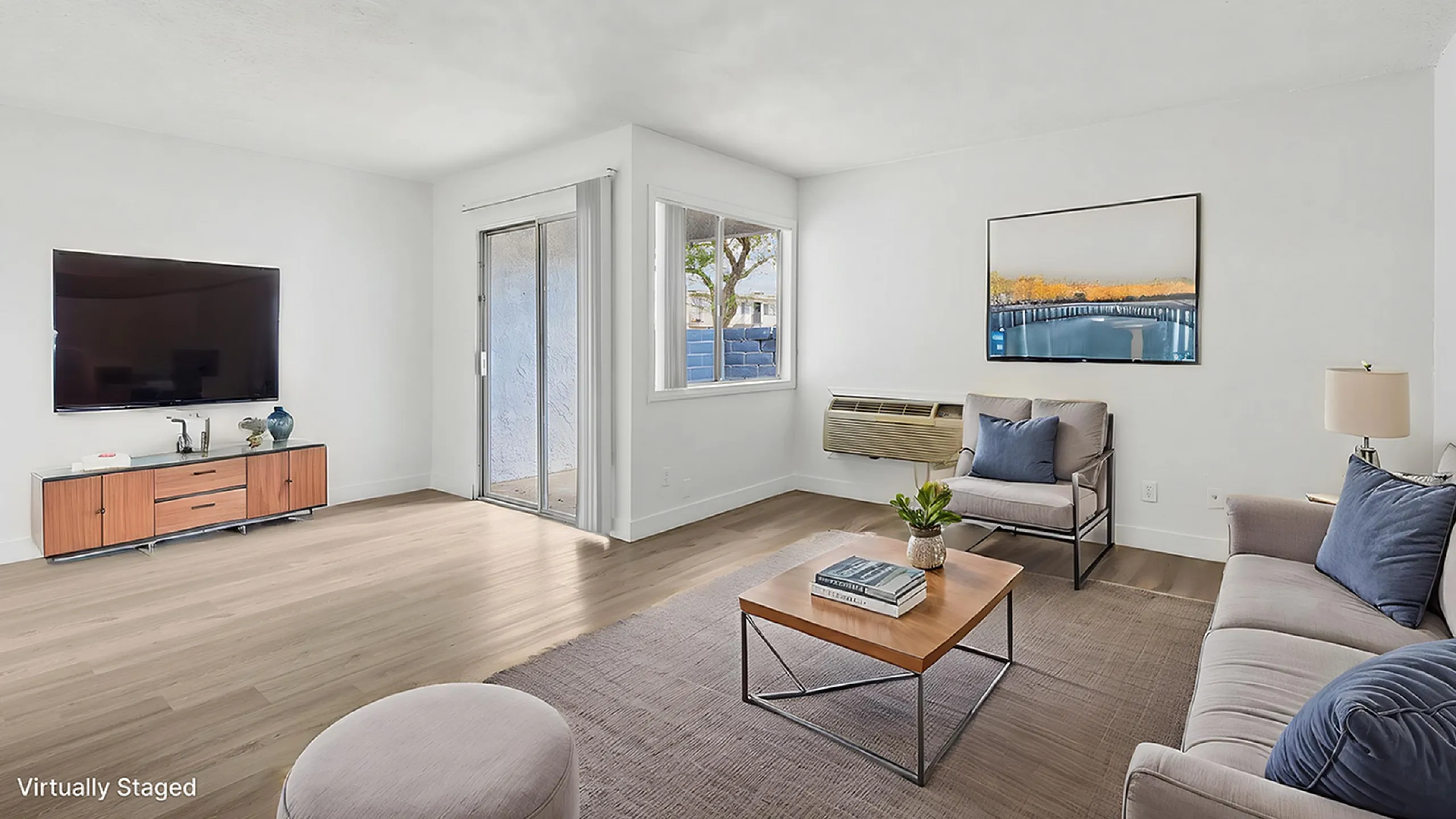 Bright and spacious virtually staged living room featuring modern furniture, large TV, and natural light from sliding door and window.