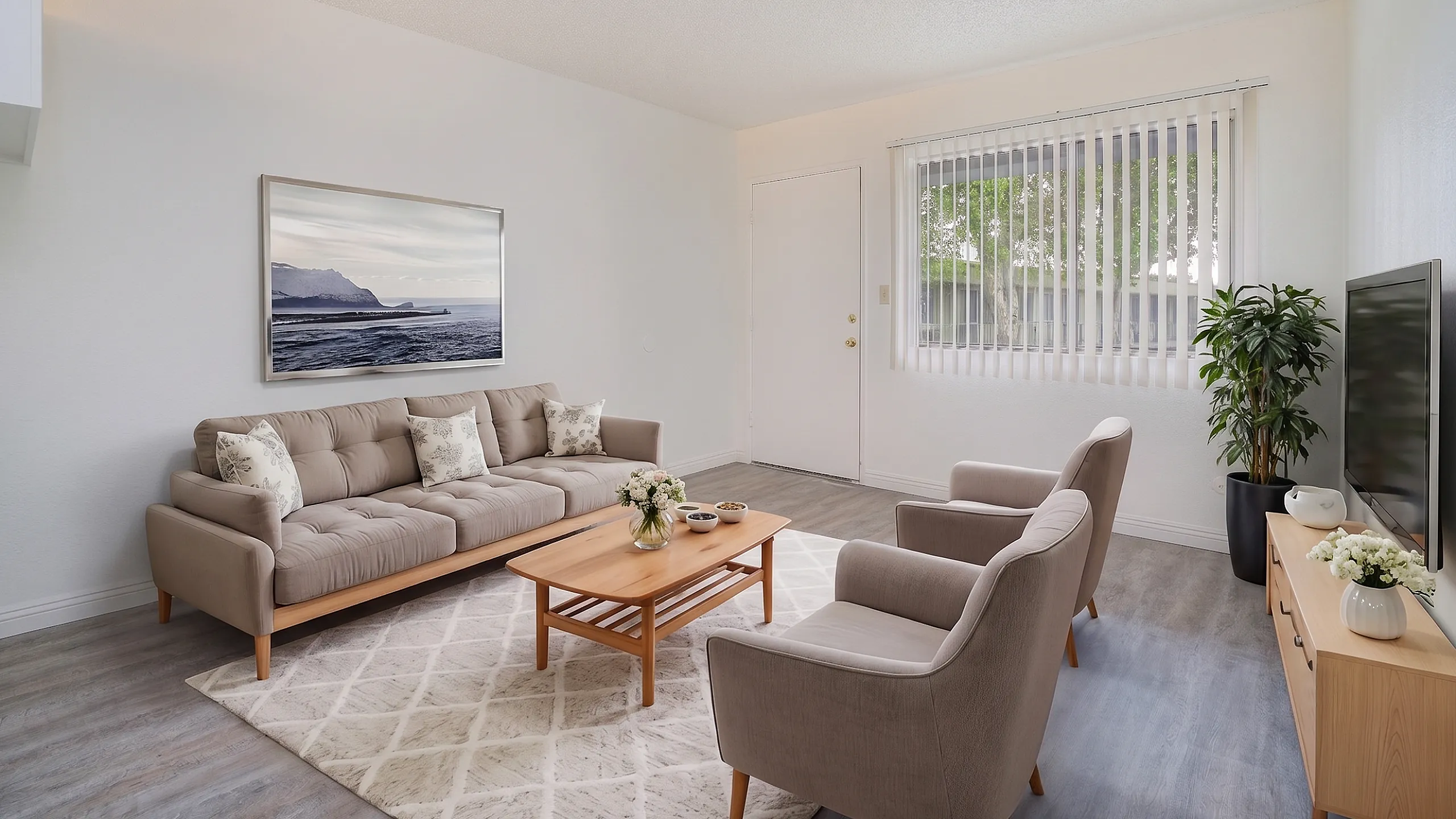 Inviting living room with modern beige furniture, elegant decor, large window providing natural light, and a serene wall art.