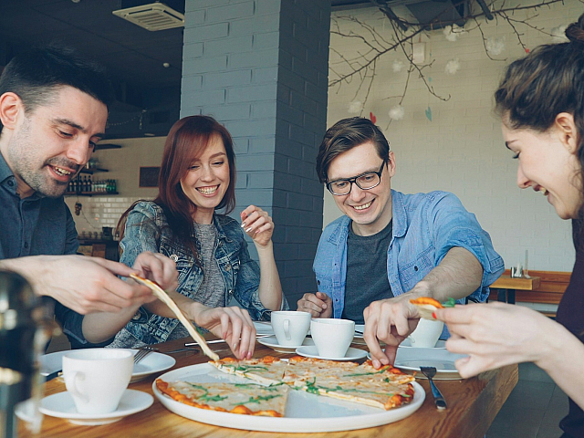 group of people eating pizza