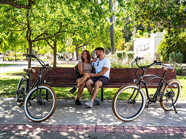 couple sitting on a bench with bikes