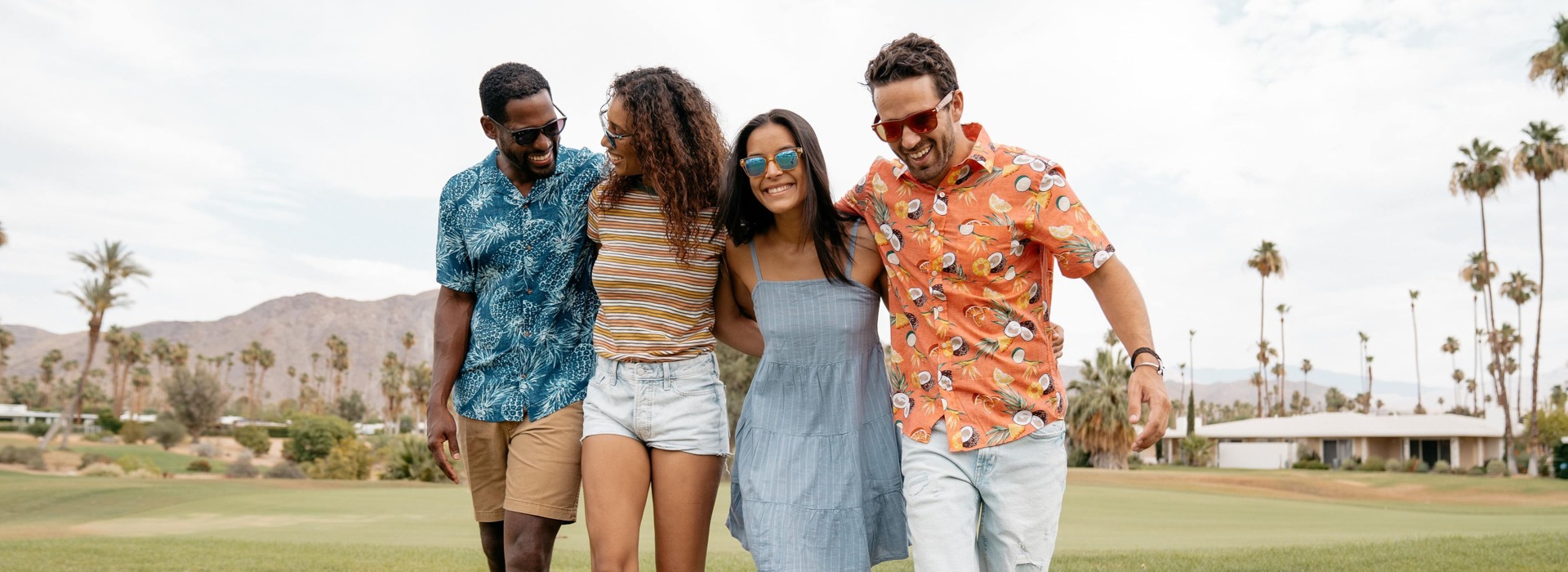 four friends walking together across golf course