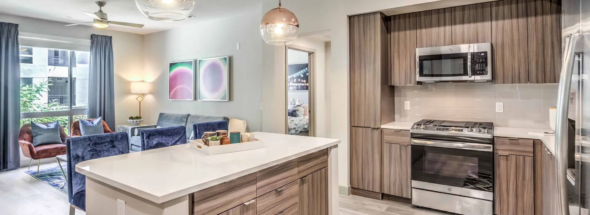 open kitchen living room with vinyl wood like flooring and stainless steel appliances at arte apartments