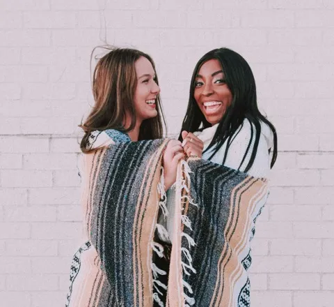 two women wrapped in a blanket
