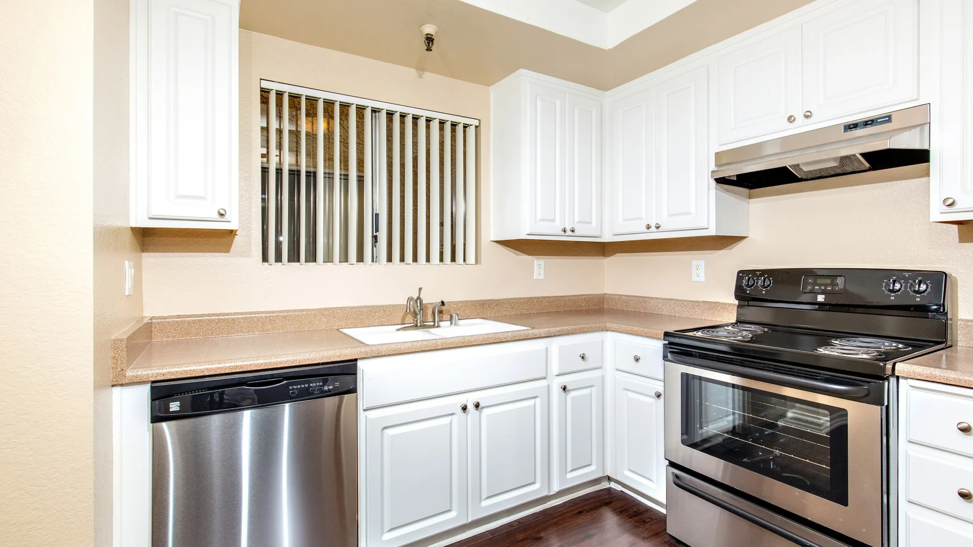 Updated kitchen with stainless steel appliances and white cabinets