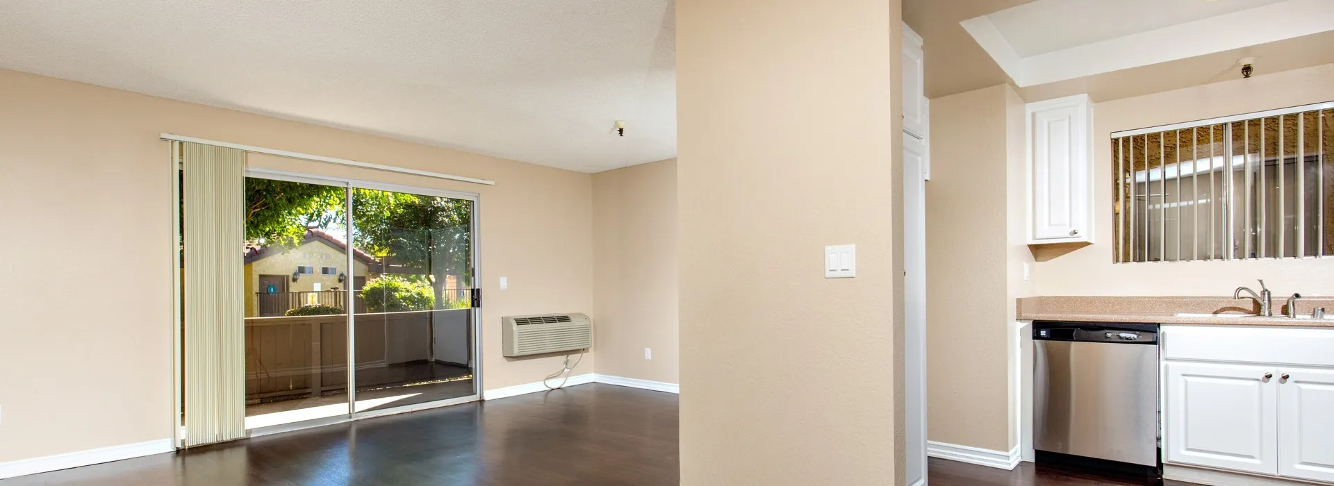 open kitchen and living room with sliding door to patio. View with lush greenery outside