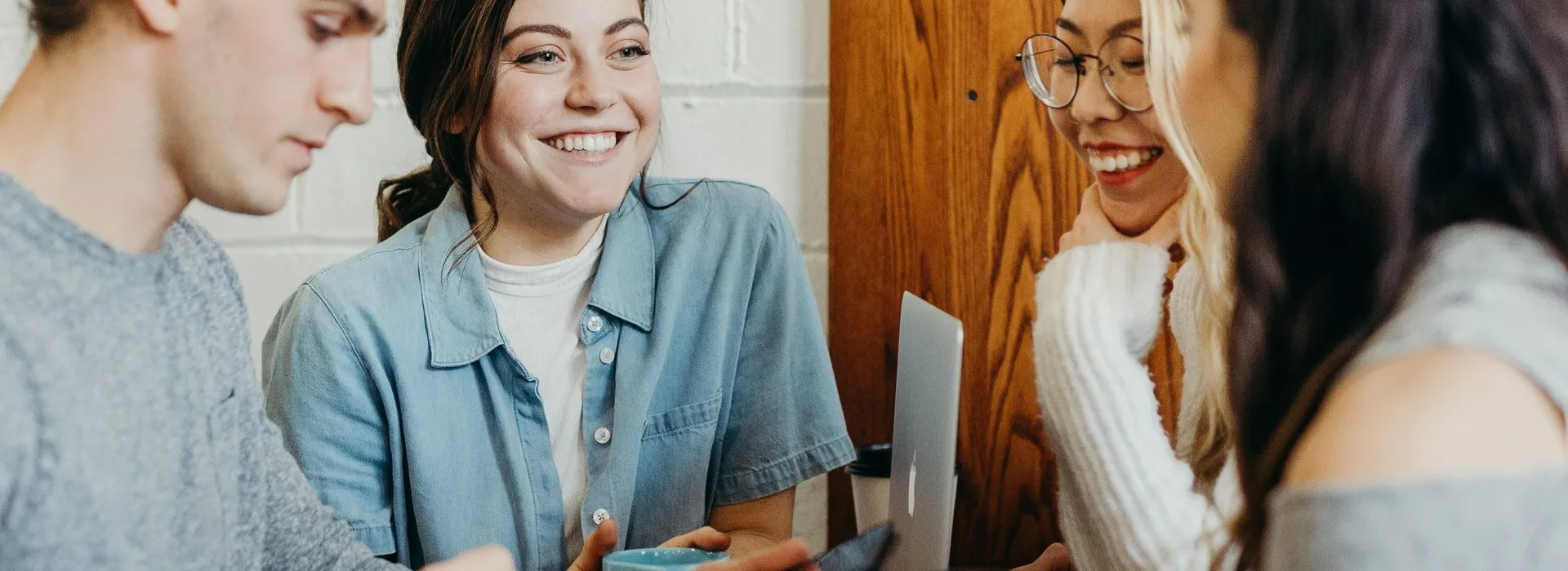 group of people laughing and smiling with computers