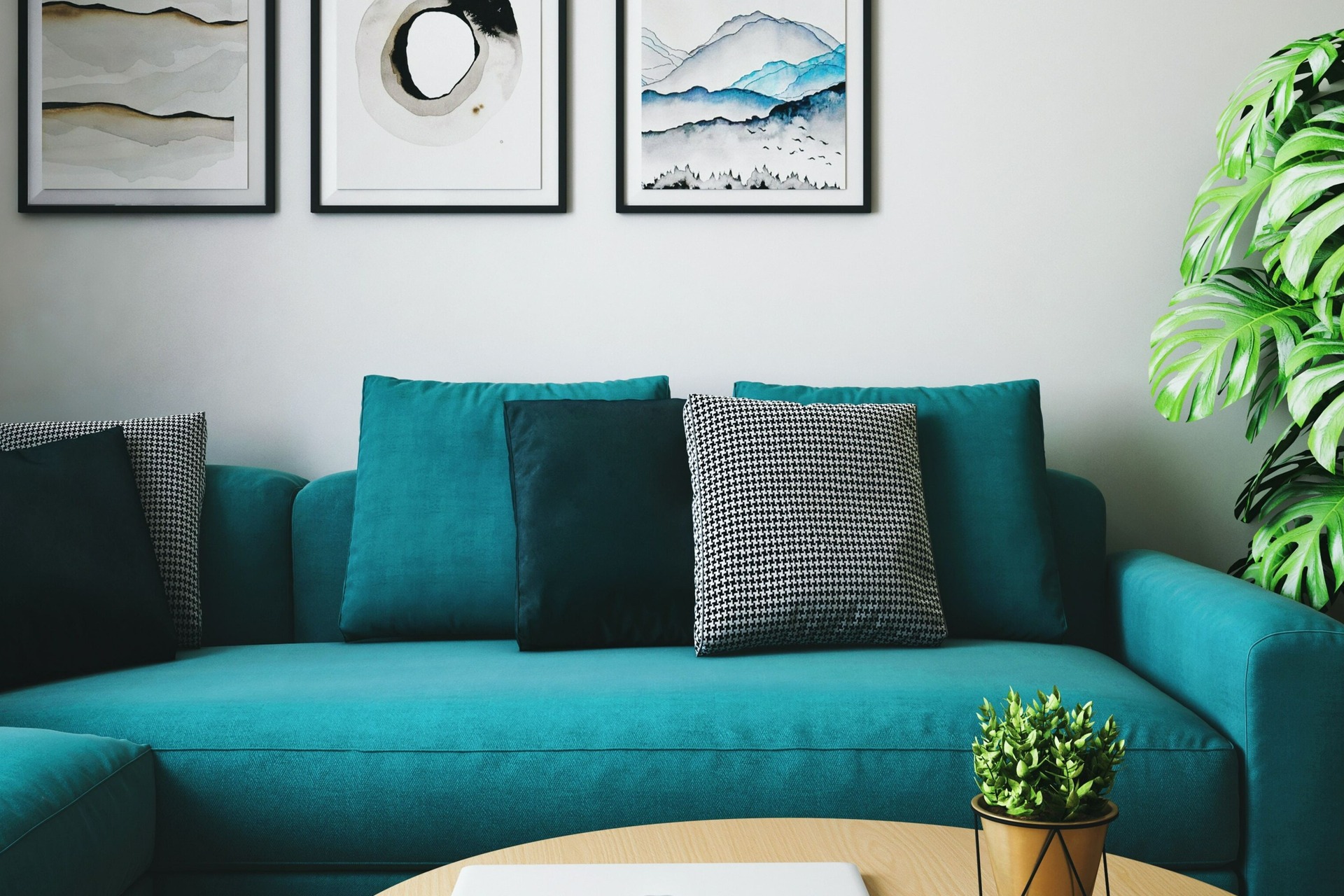 Blue couch with table and tropical plants with abstract art
