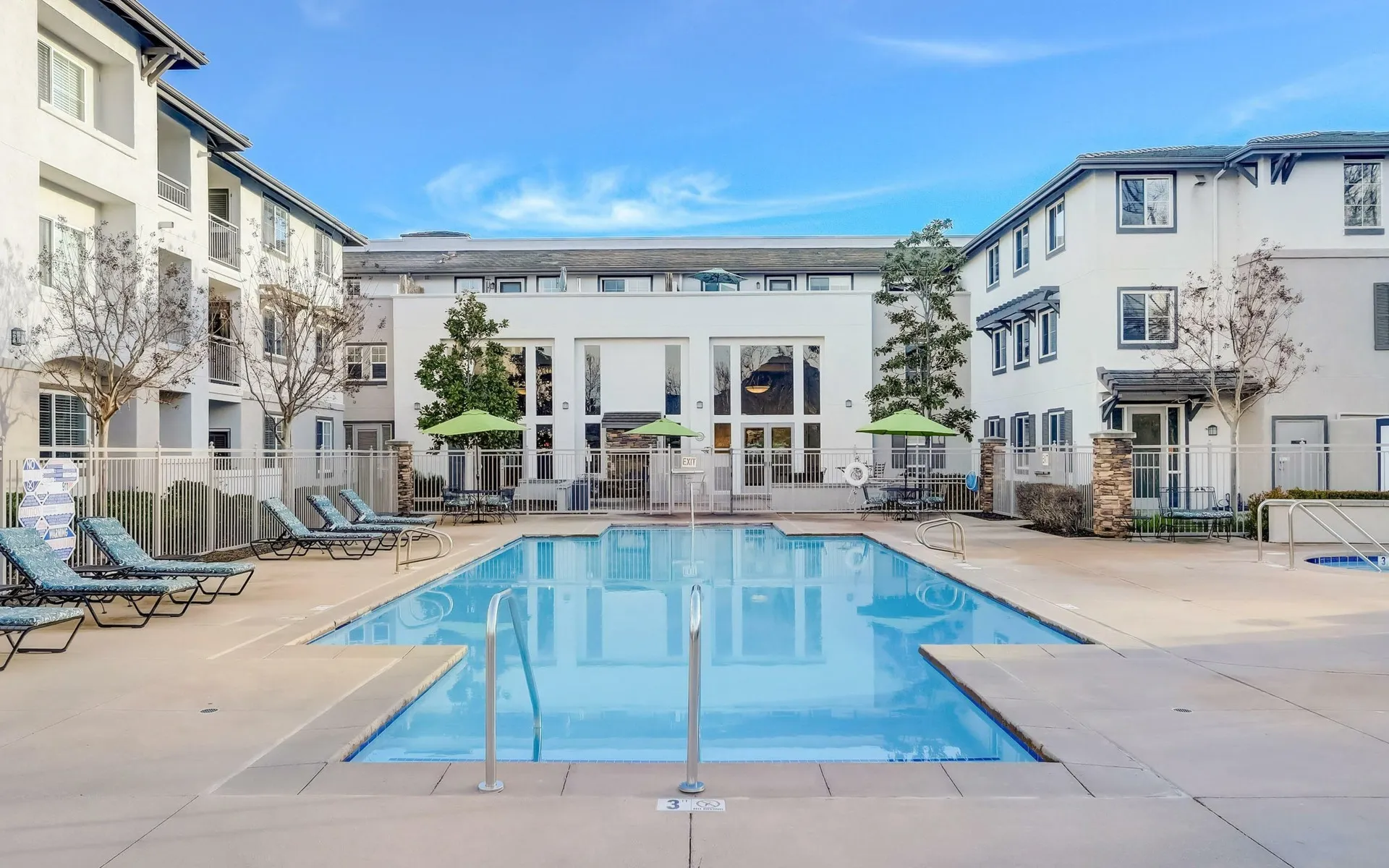Royal Oaks Pool & lounge area with hot tub and umbrellas