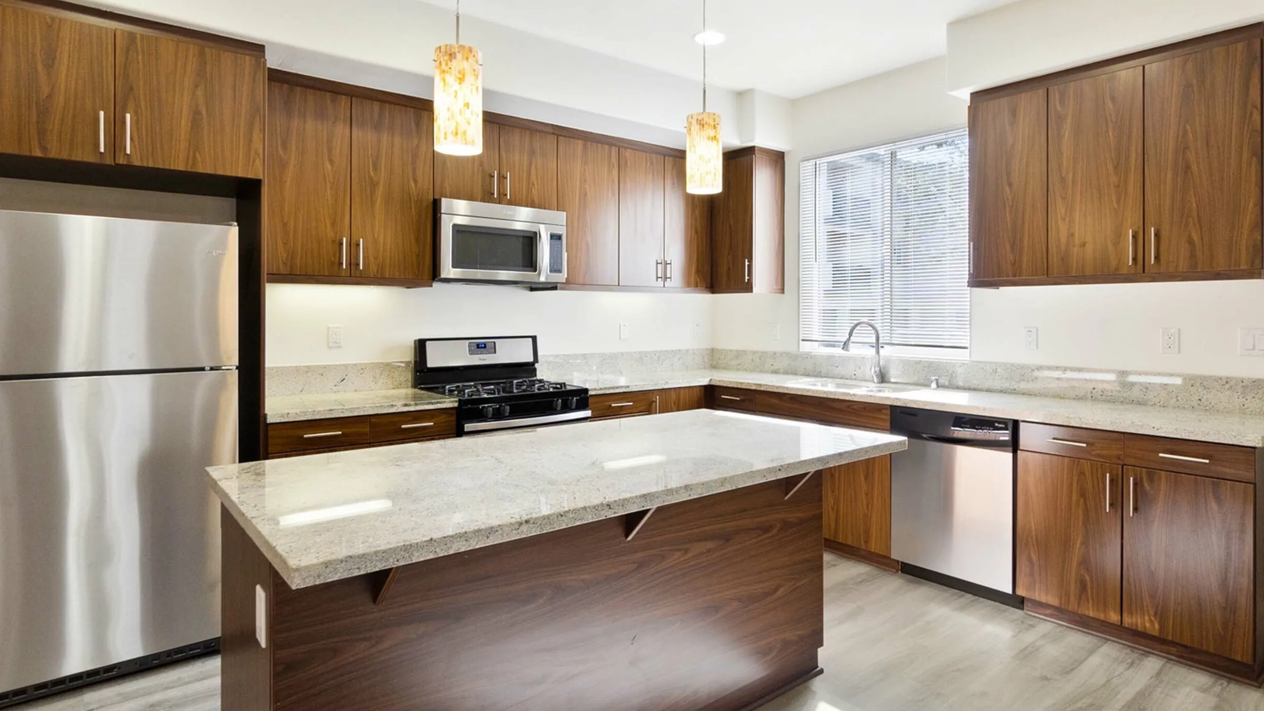 kitchen with island and stainless steel appliances at luxliv apartments