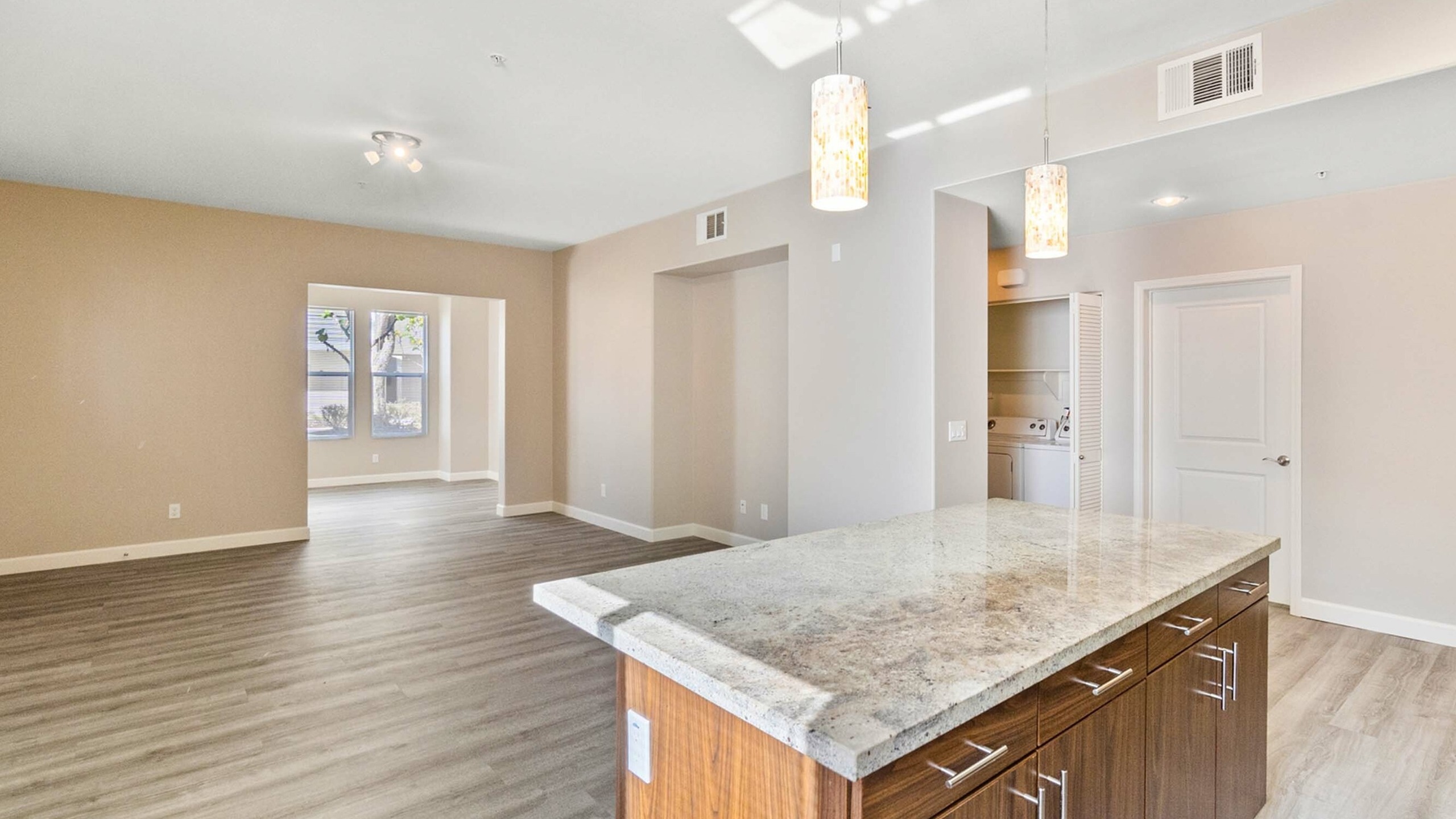 kitchen island with granite countertops and living room with wood like flooring