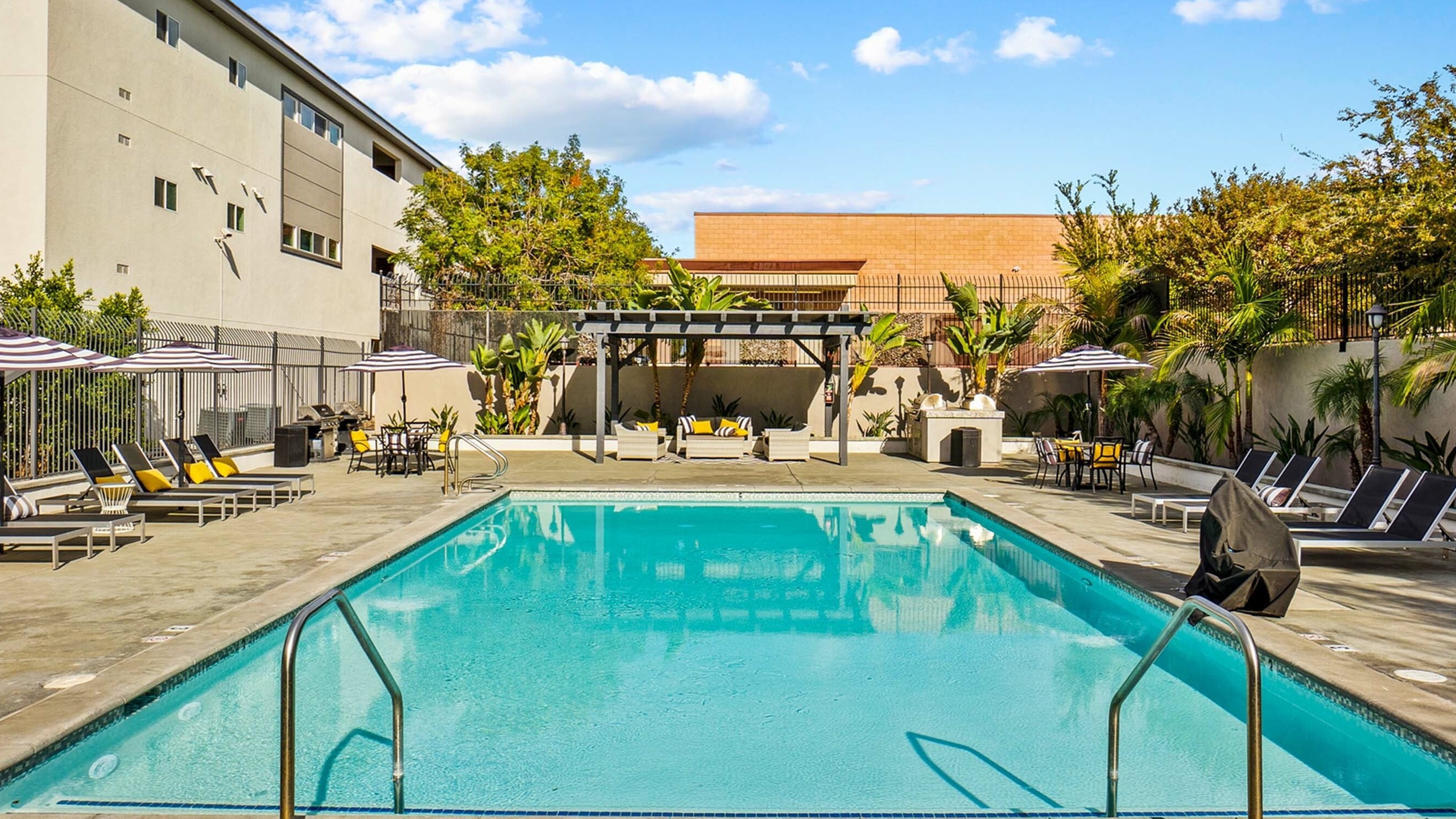 pool with lounge chairs and tables and a seating area under a terrace