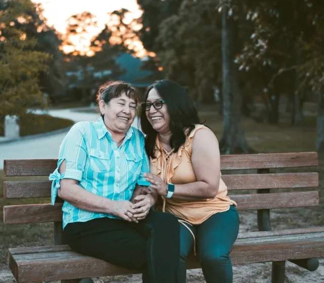 women smiling and laughing on bench