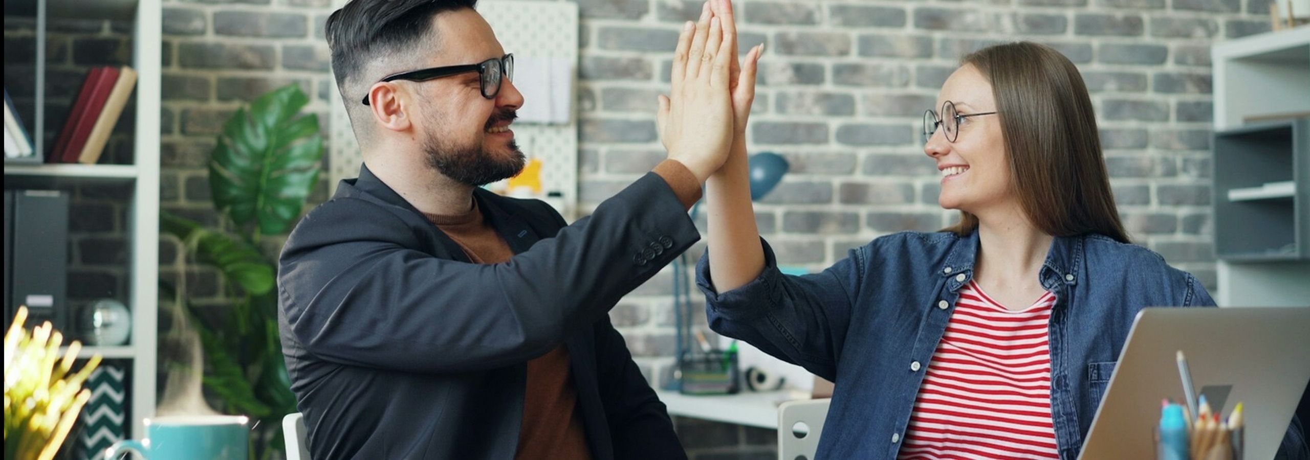two people at work high fiving