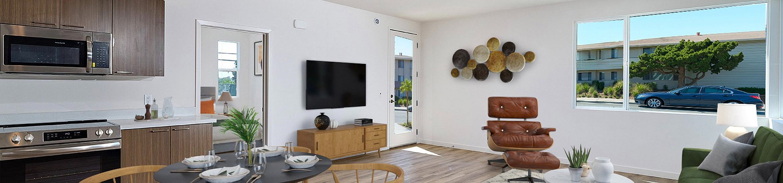 virtually staged living room with faux wood like flooring and kitchen with stainless steel appliances at DEZI