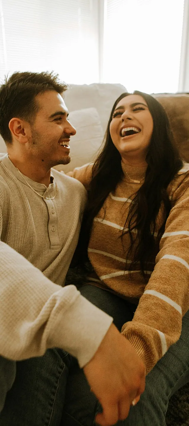 couple laughing while sitting on the floor
