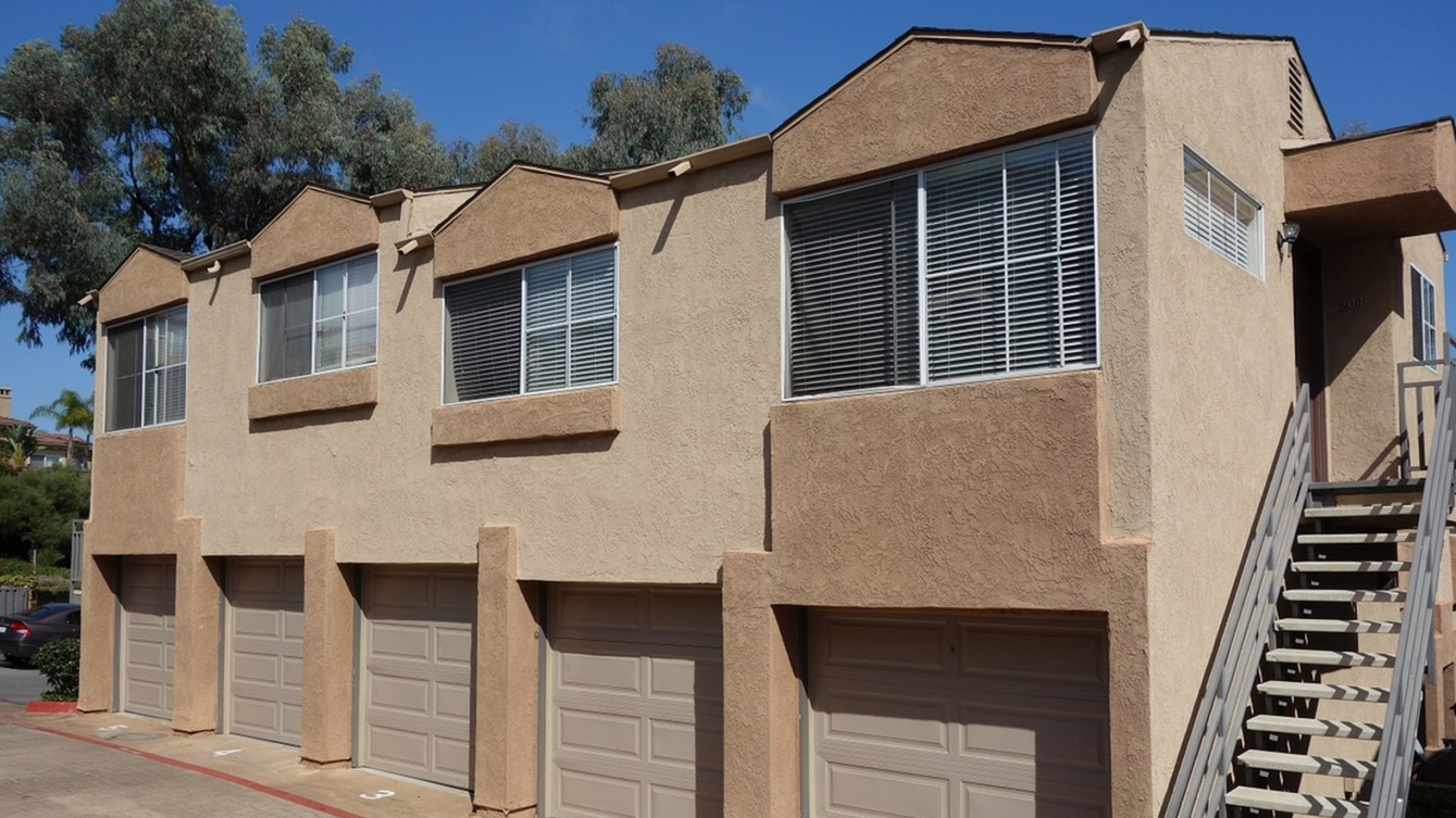 Exterior view of a community building featuring a row of attached garages available for residents.