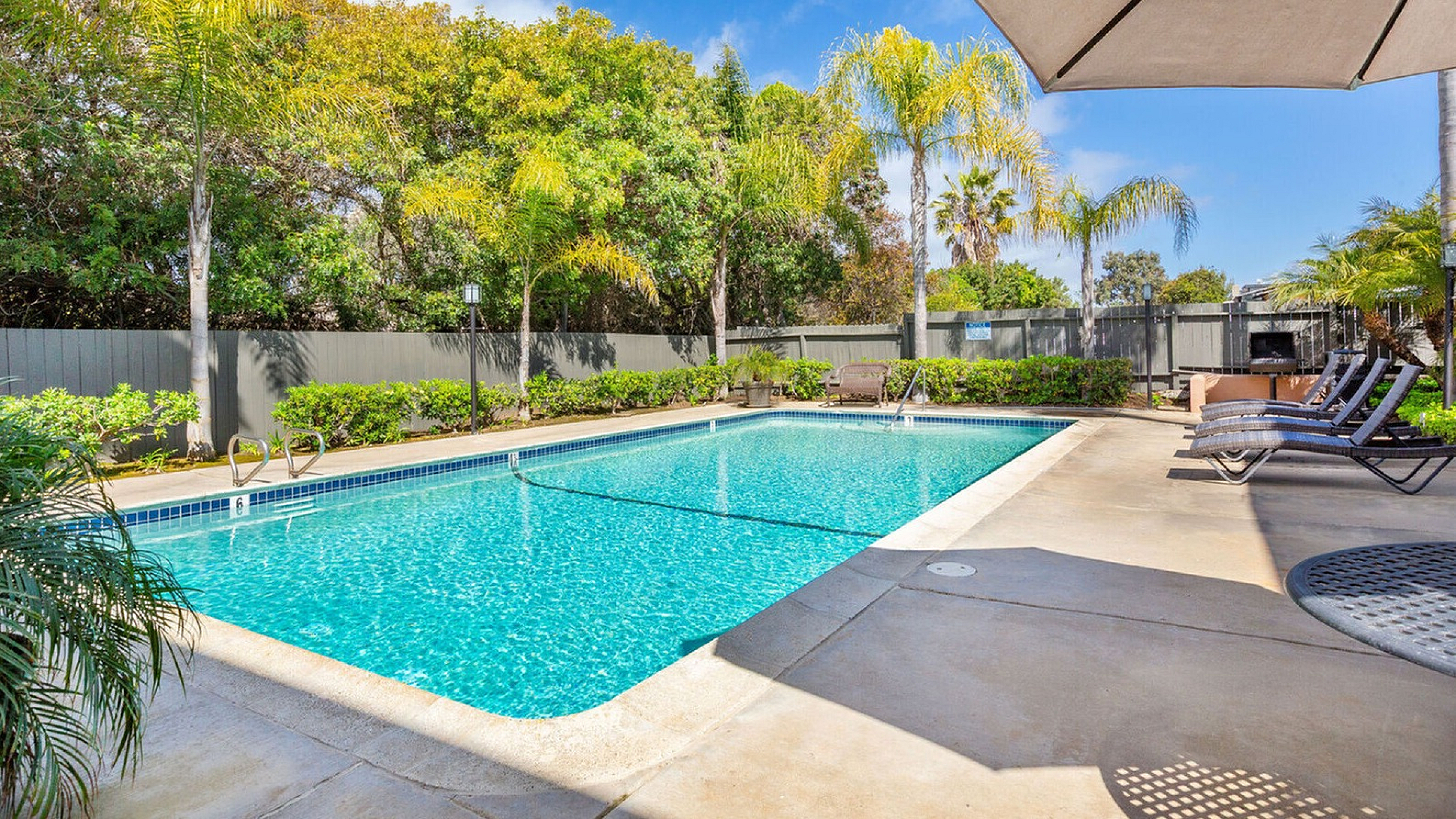 Sparkling swimming pool and sun deck with lounge chairs at Elan - Sandpiper Del Mar