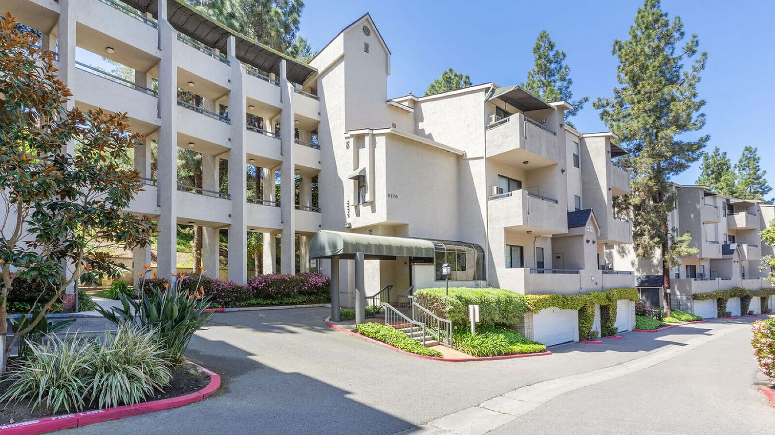 Multi-story apartment building with lush landscaping at Elan - Terraza La Jolla