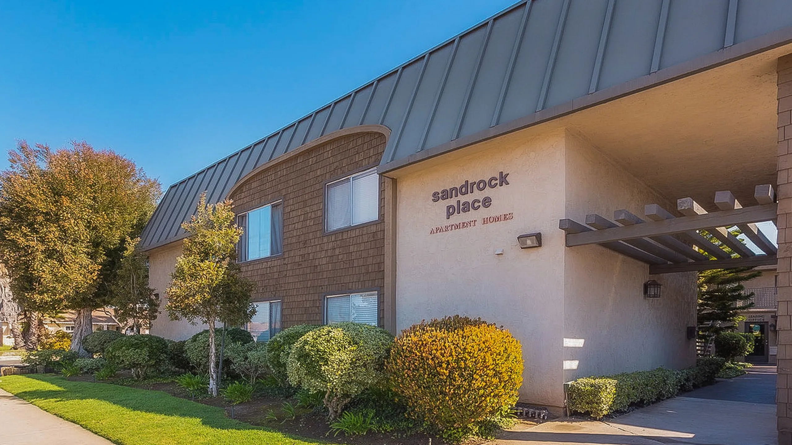 Modern apartment building exterior with professional landscaping at Elan - Sandrock Place