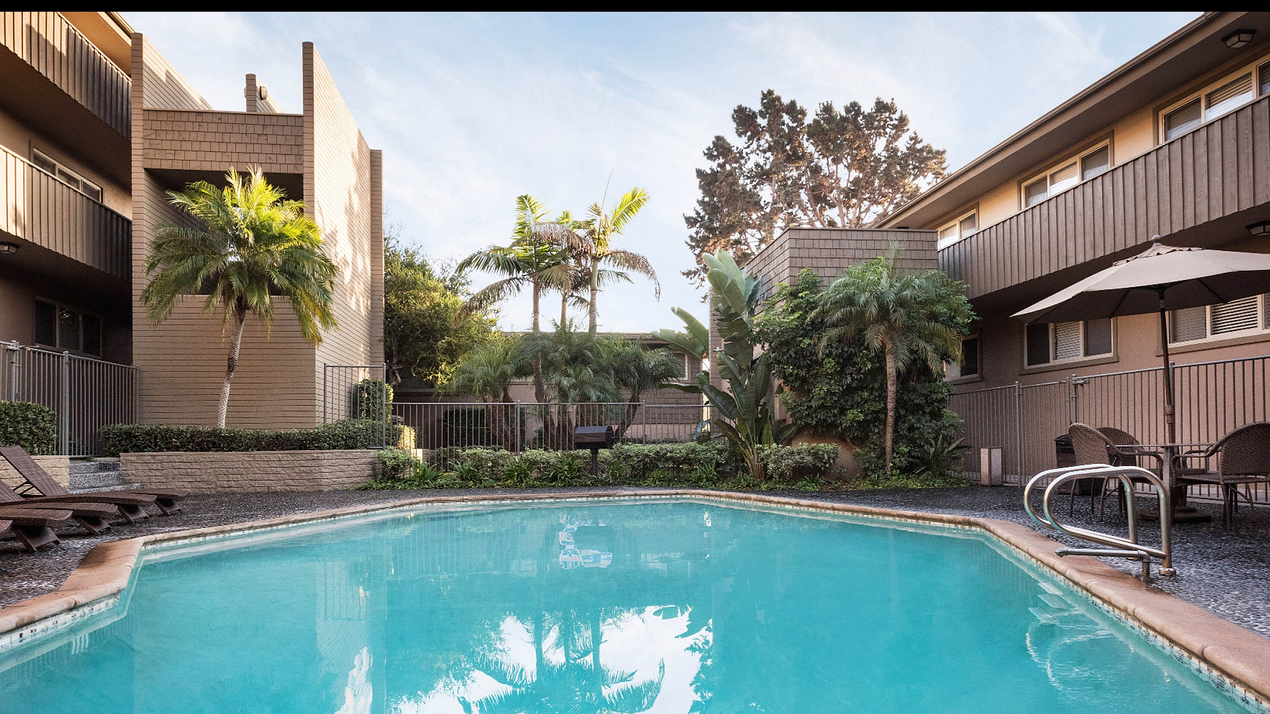 Sparkling swimming pool and sun deck with lounge chairs at Elan - Baylofts