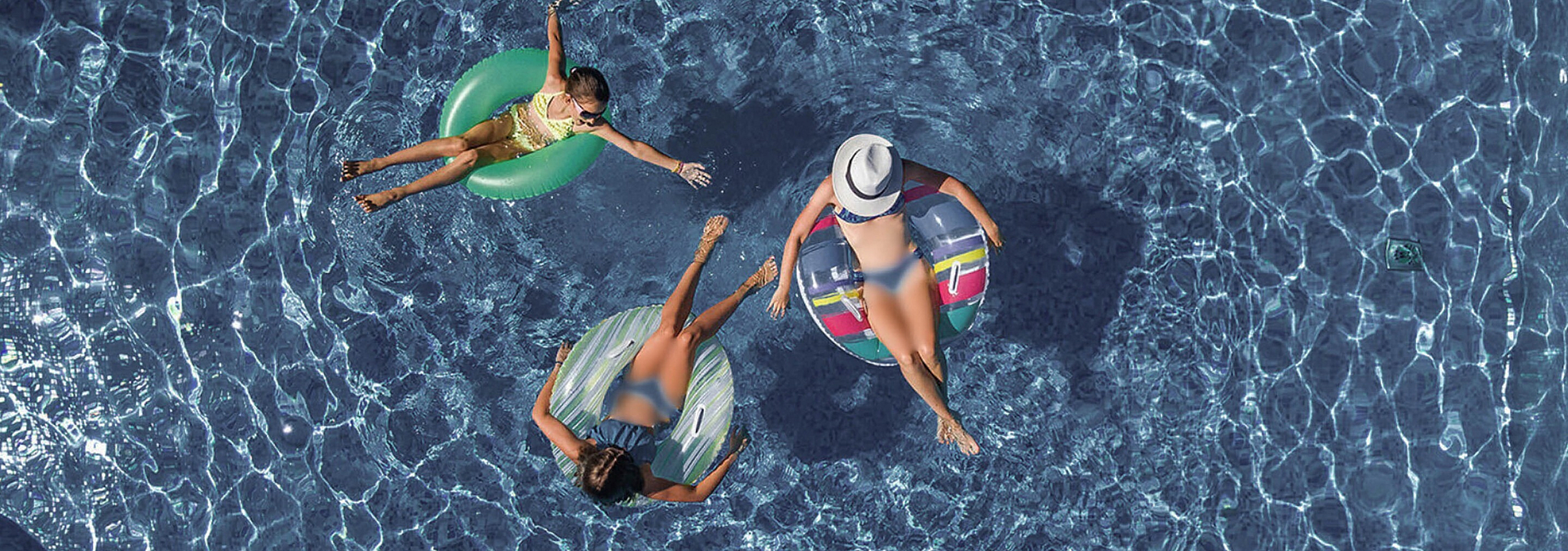 three women floating in the pool
