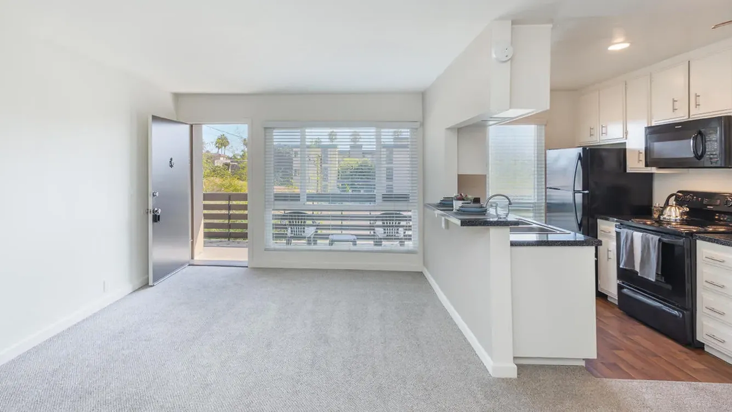 Bright living space featuring a large window and kitchen view at Elan - pacific lofts