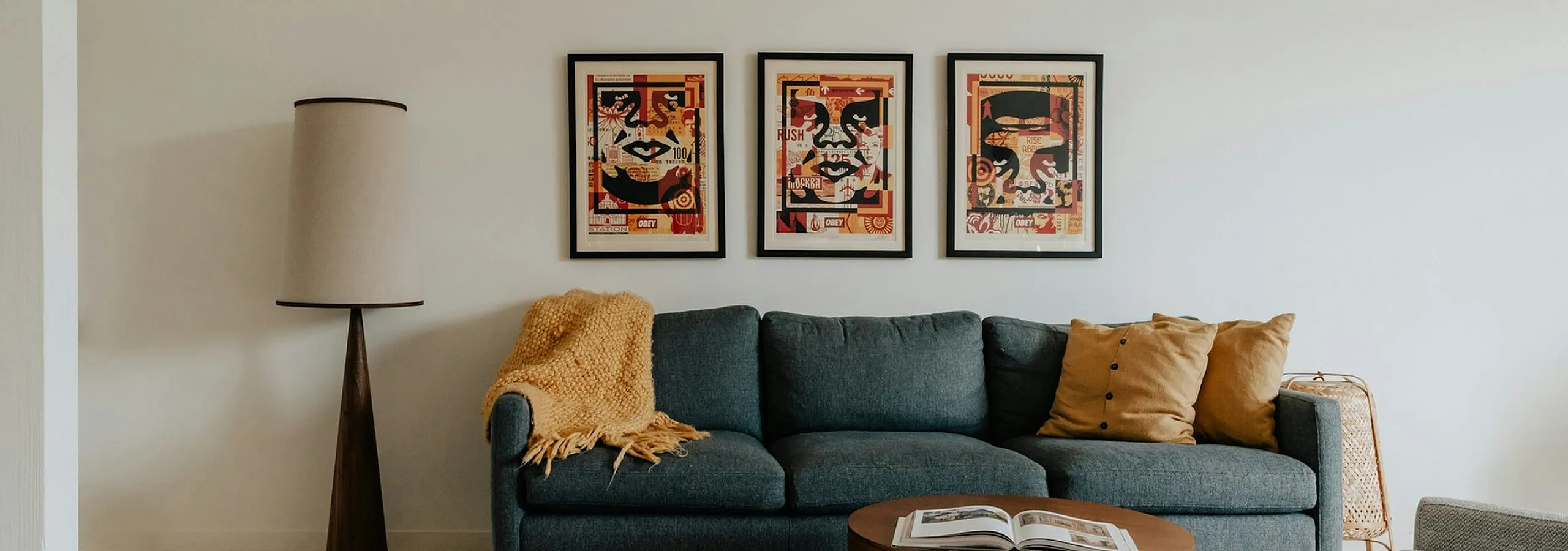 grey sofa with yellow accent pillows and obey giant art frames behind