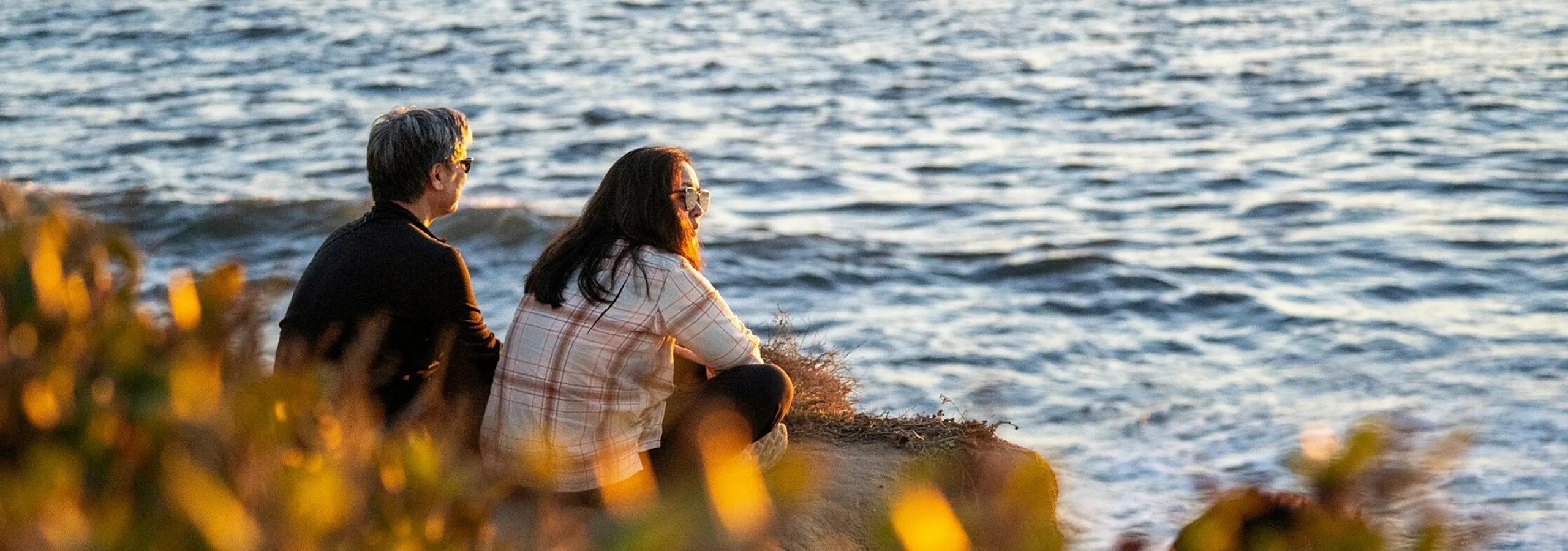 two people sitting near the water