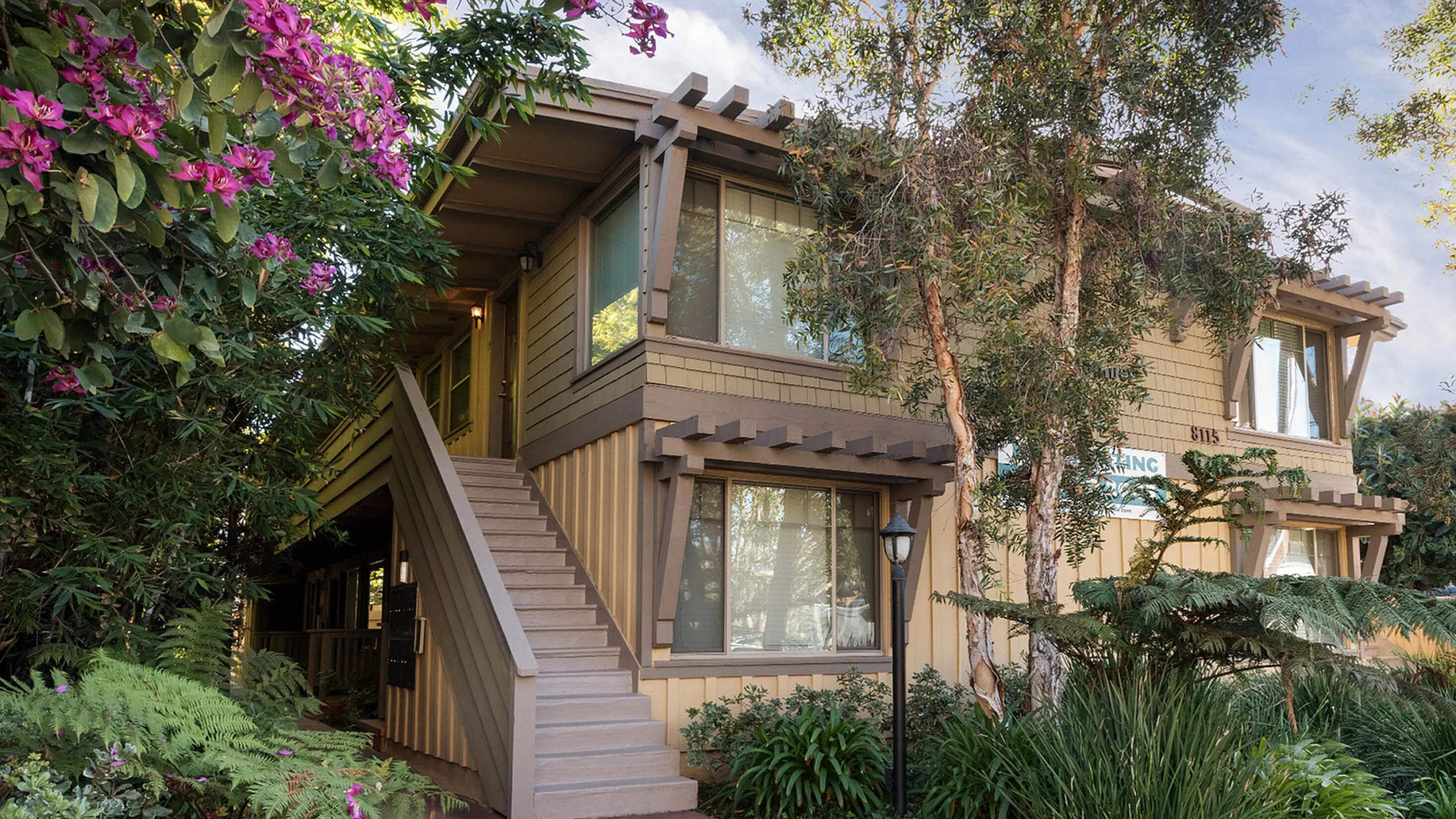 Coastal apartment exterior and lush green landscaping at Elan - beachcomber la jolla.