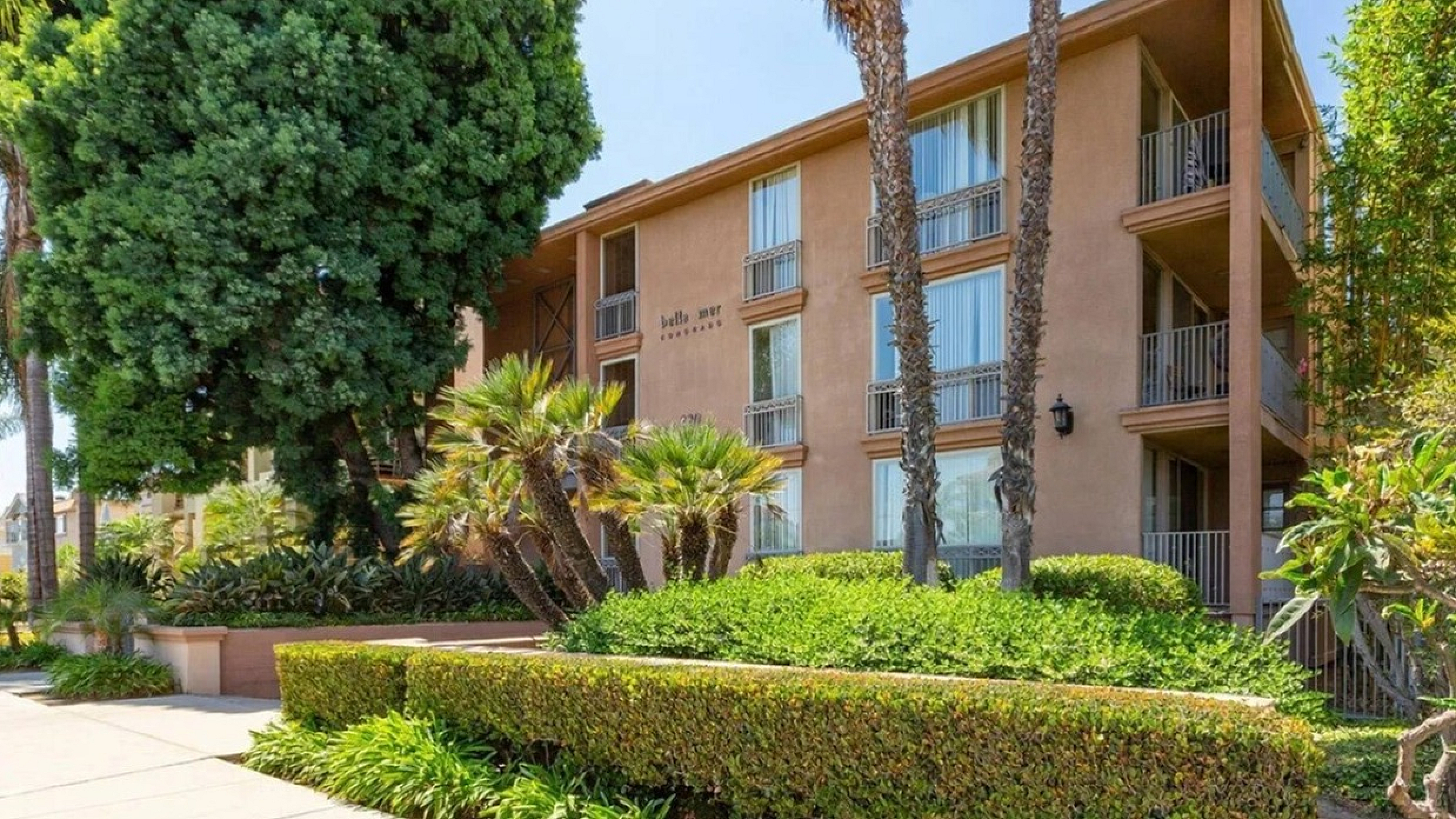 Coastal apartment building exterior with professional landscaping at Elan - bella mer coronado.
