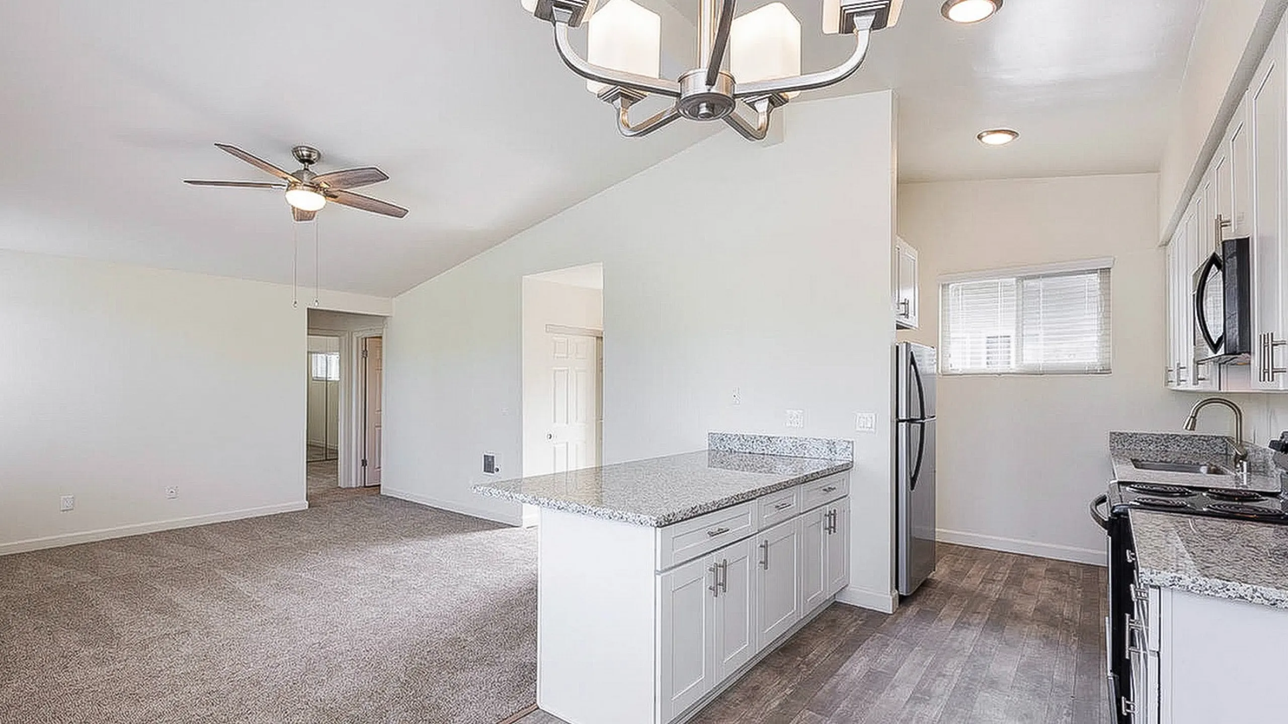 Open living area and kitchen with plush carpet at Elan - beachhouse del mar