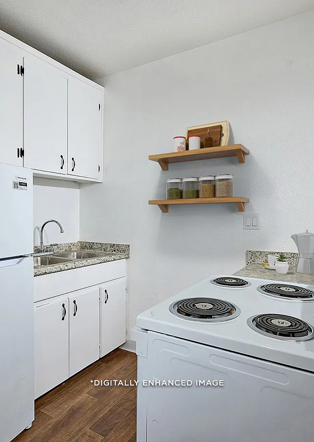 virtually staged Kitchen with refrigerator, sink, and stove