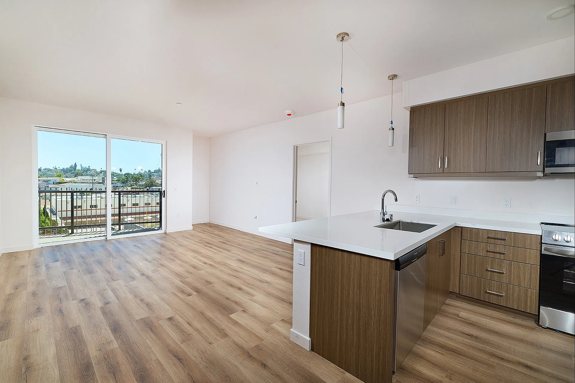 Bright open floor plan at textur featuring a modern kitchen with a breakfast bar and a sliding door to the balcony.