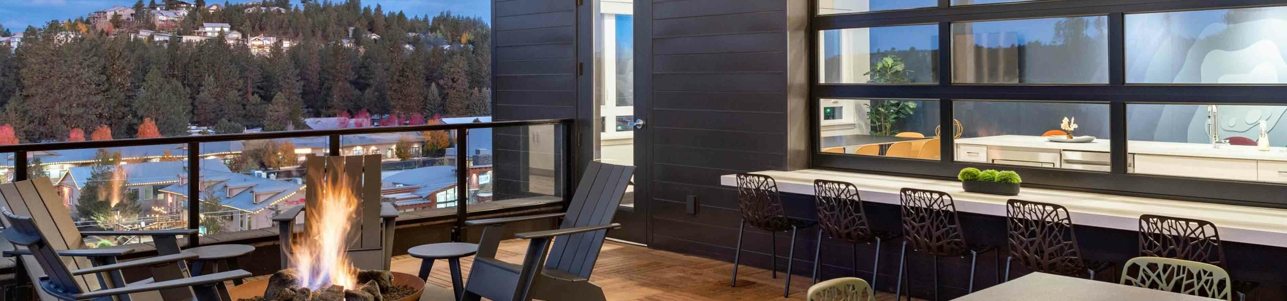 rooftop deck with panoramic Bend, OR views, fire pit, and indoor-outdoor resident lounge space