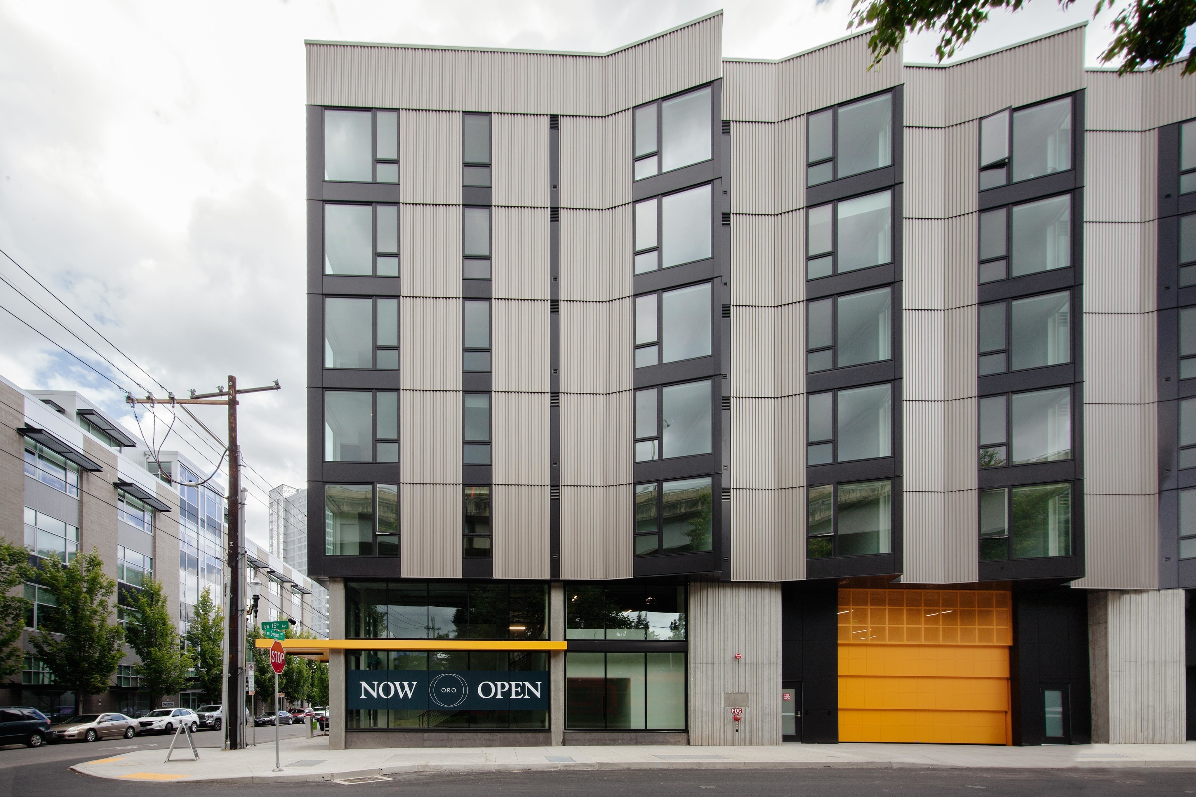 Studios in Downtown Portland OR - ORO - An exterior shot of The Apartment Building with Black, Yellow, and Grey Details and Many Windows