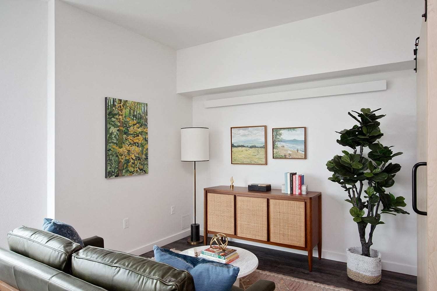 Downtown Portland, OR Apartments - ORO - Living Room with a Leather Sofa, Wood-Style Flooring, and Stylish Decor