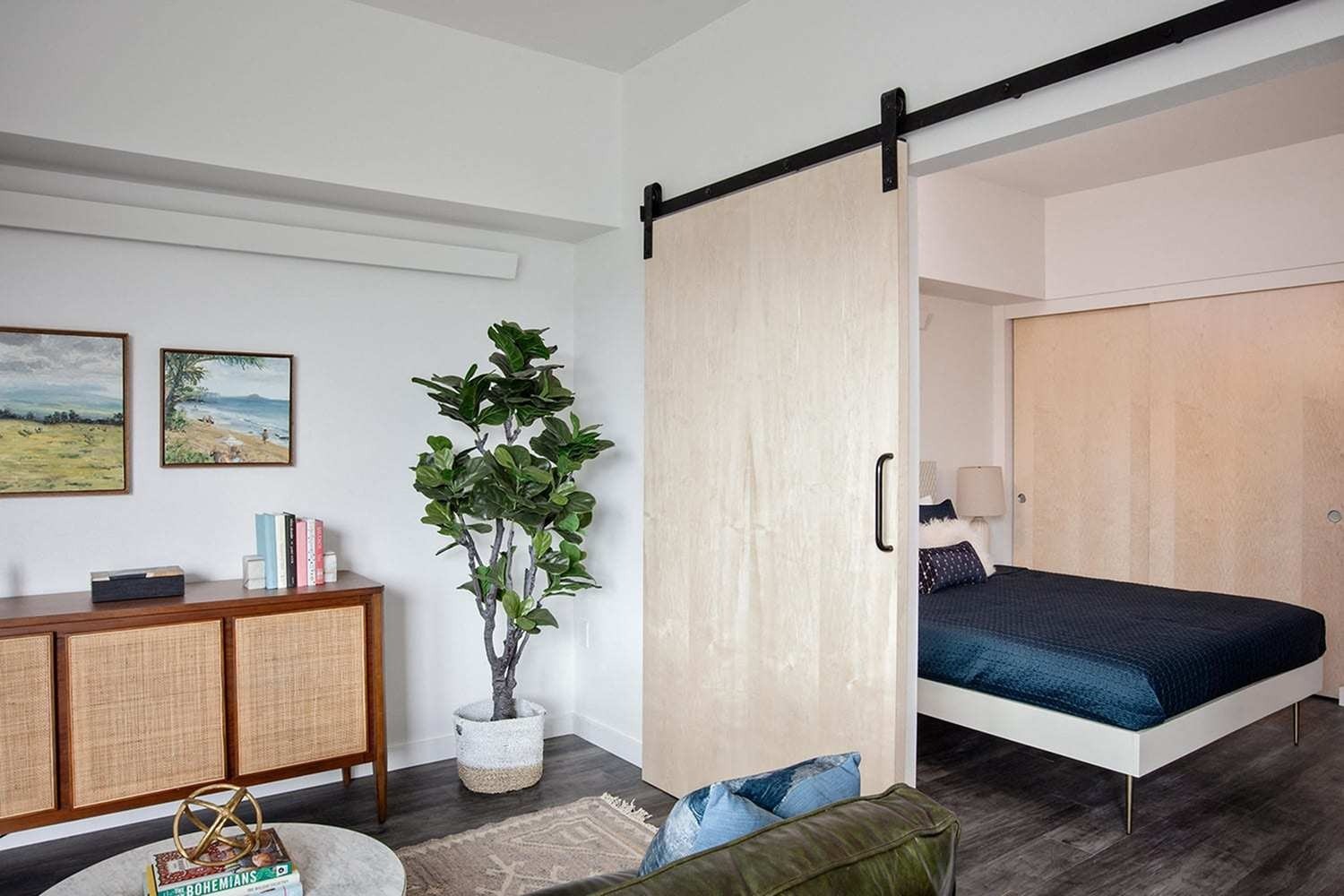 Slabtown, OR Apartments - ORO - Furnished Living Room And Bedroom With Wood-Style Flooring, A Barn Door, And A Large Closet