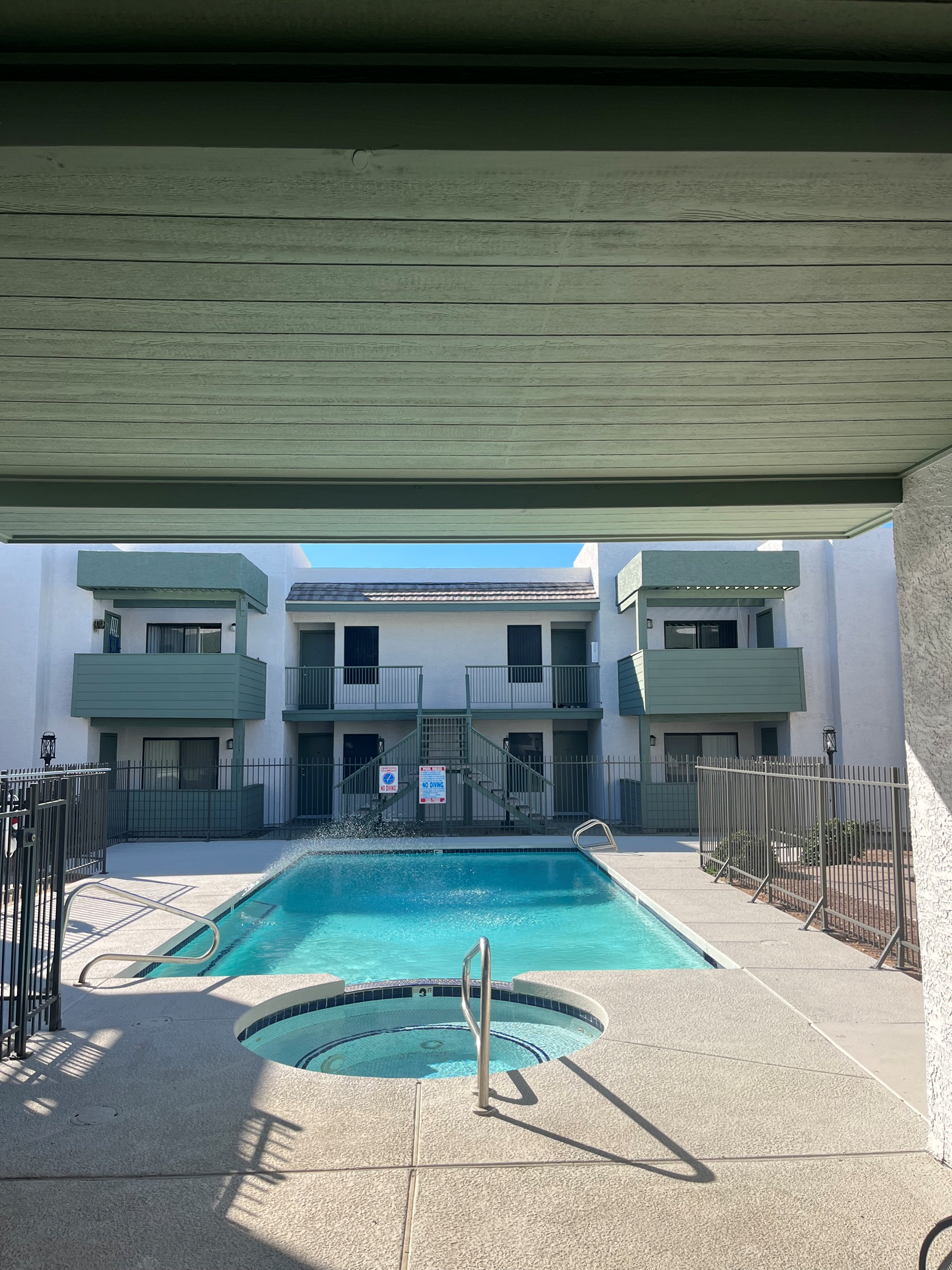 view of gated pool and hot tub from first floor at Monterey Apartments