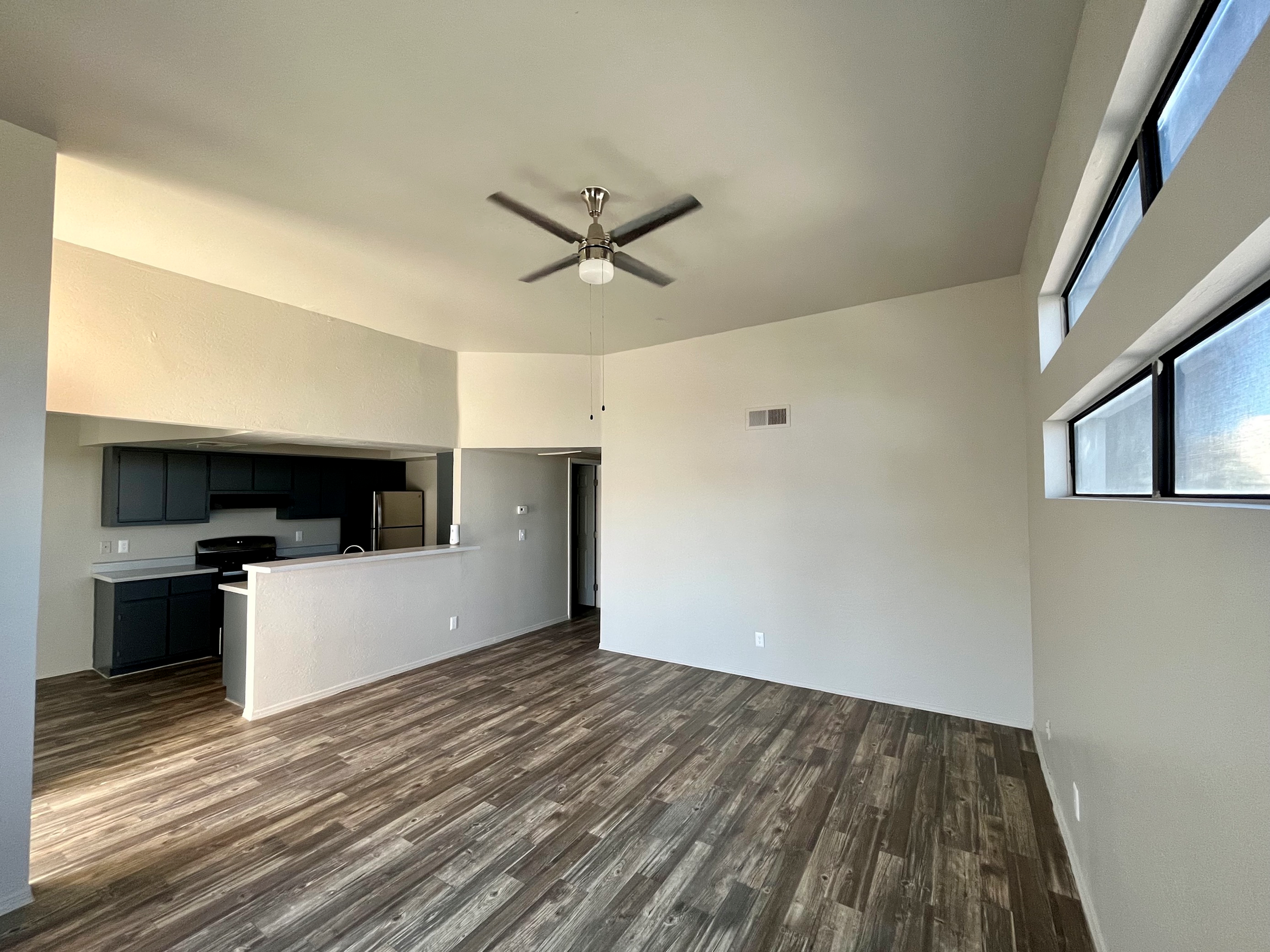 living room with vinyl wood like flooring and ceiling fan at Monterey Apartments
