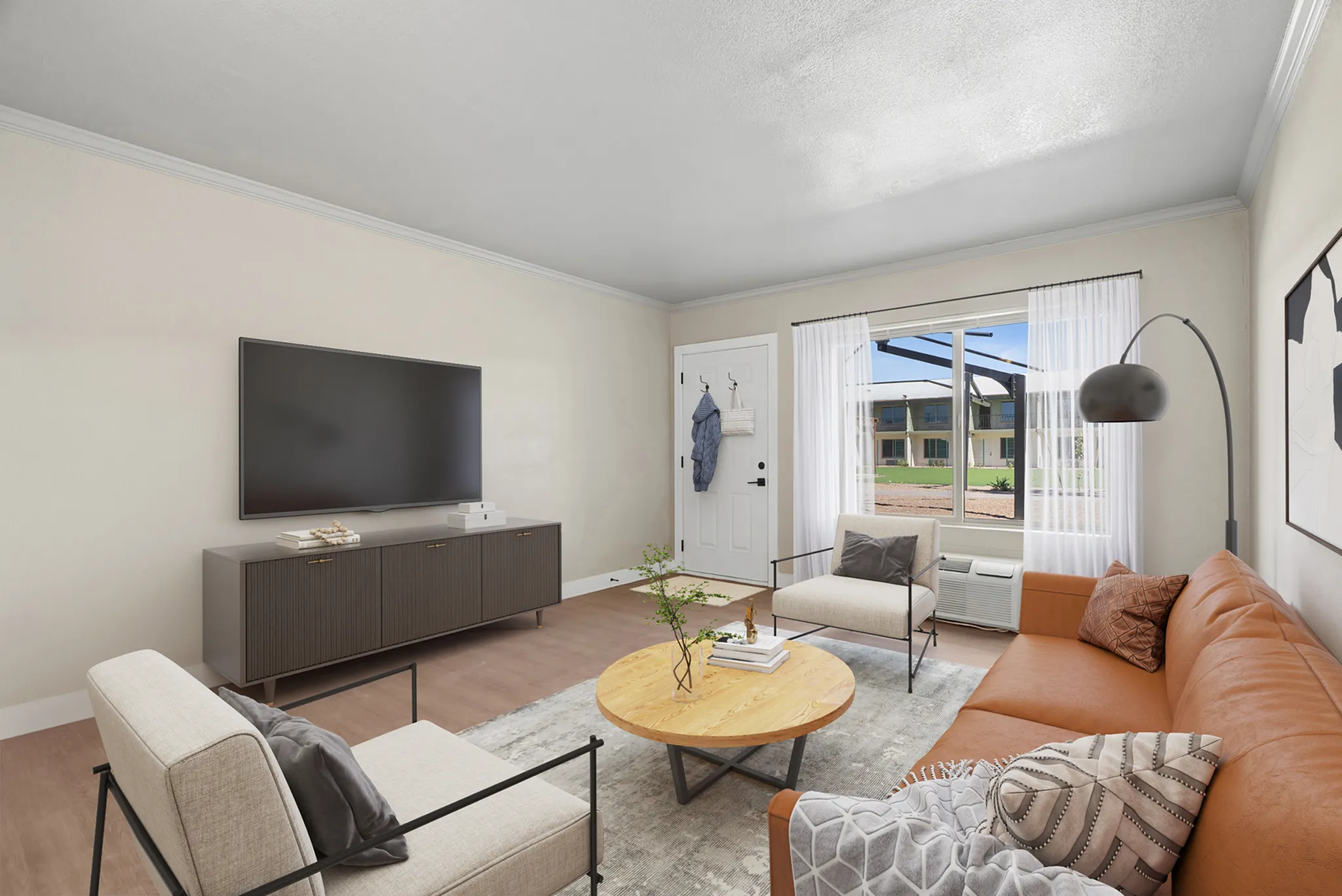 Virtually staged one-bedroom at Solaris at Tucson showing the living room with a couch, chair, tv