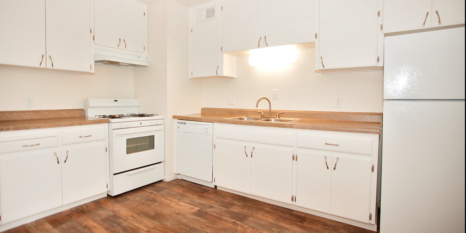 kitchen with white cabinets and vinyl wood like flooring at Solaris