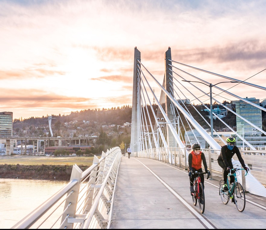 two people cycling across bridge in portland