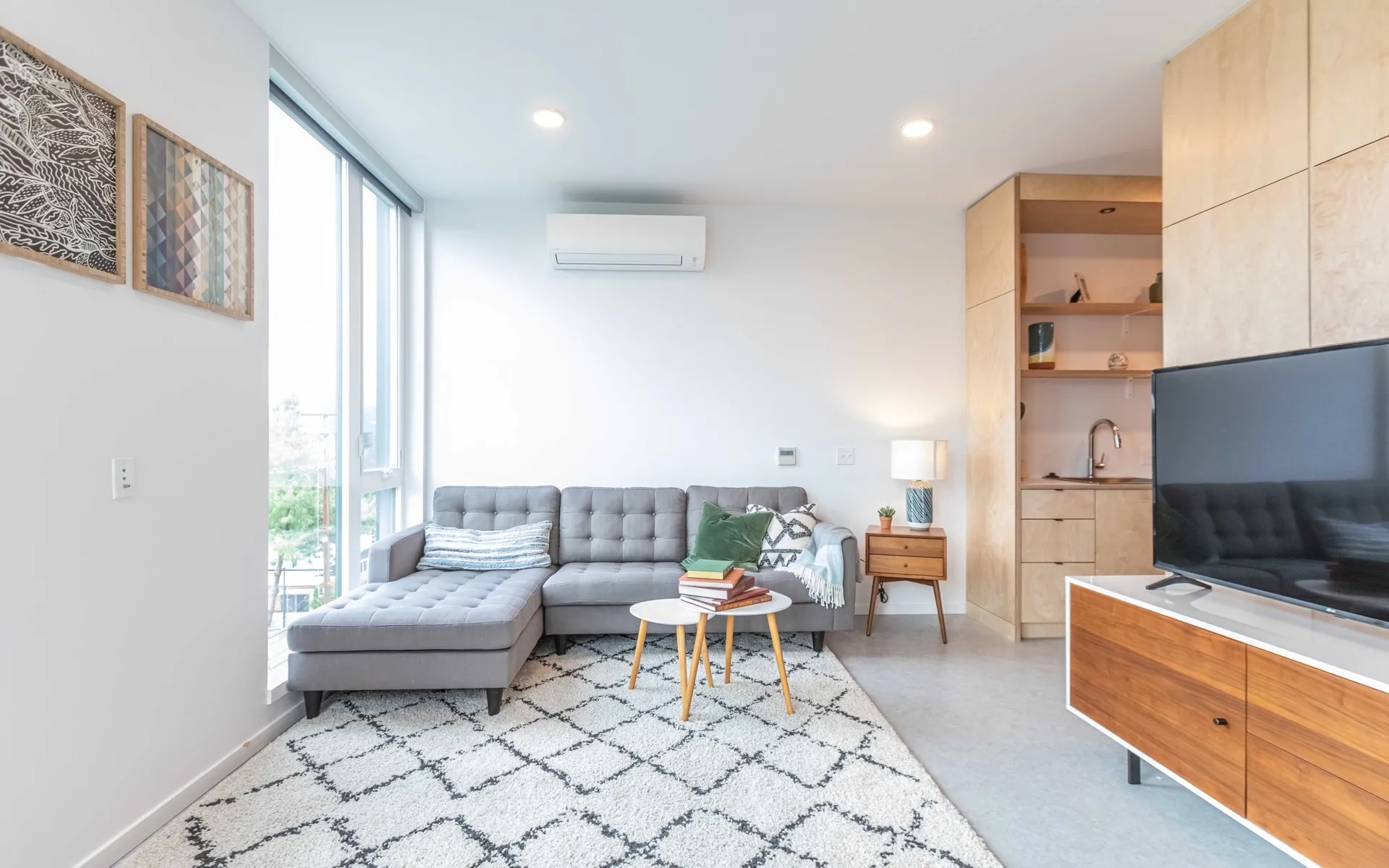 living room with grey sofa and white area rug at Artisan