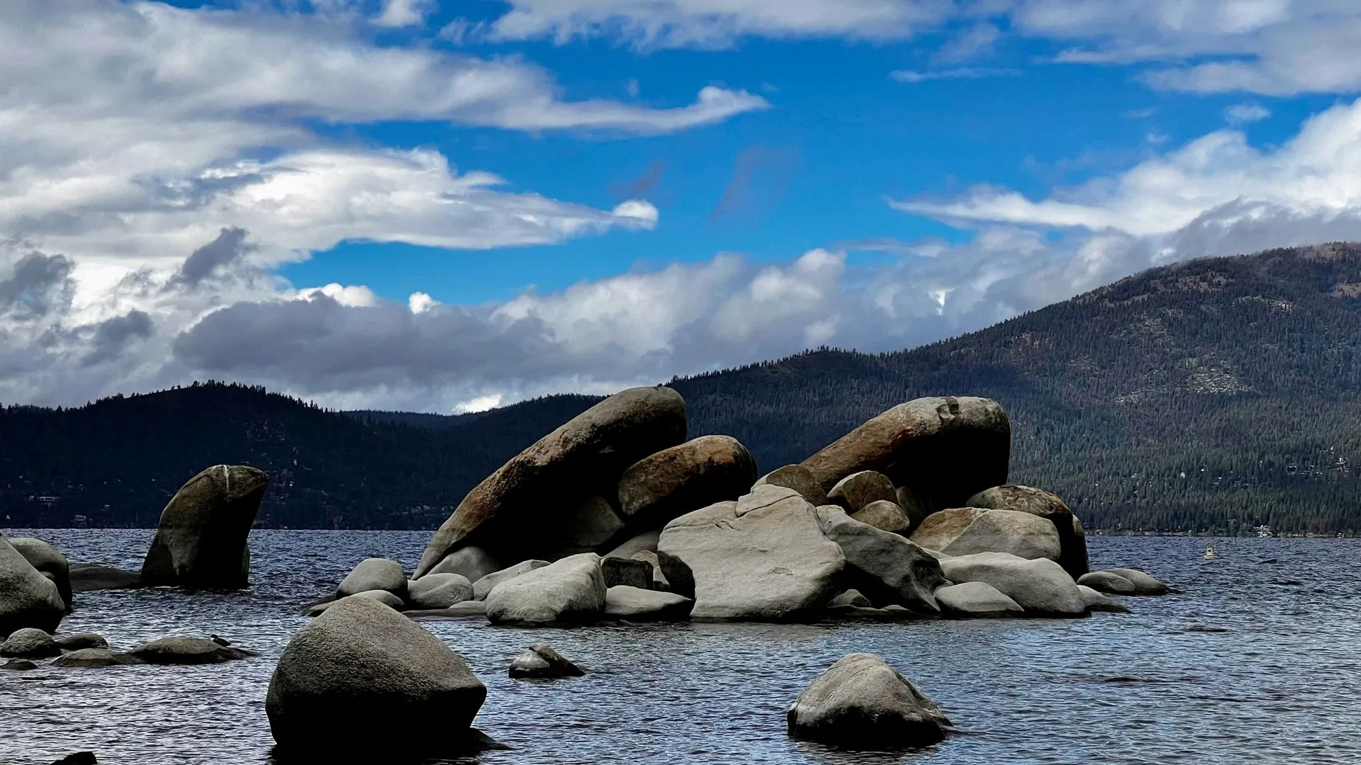 lake with rocks and mountain in the background