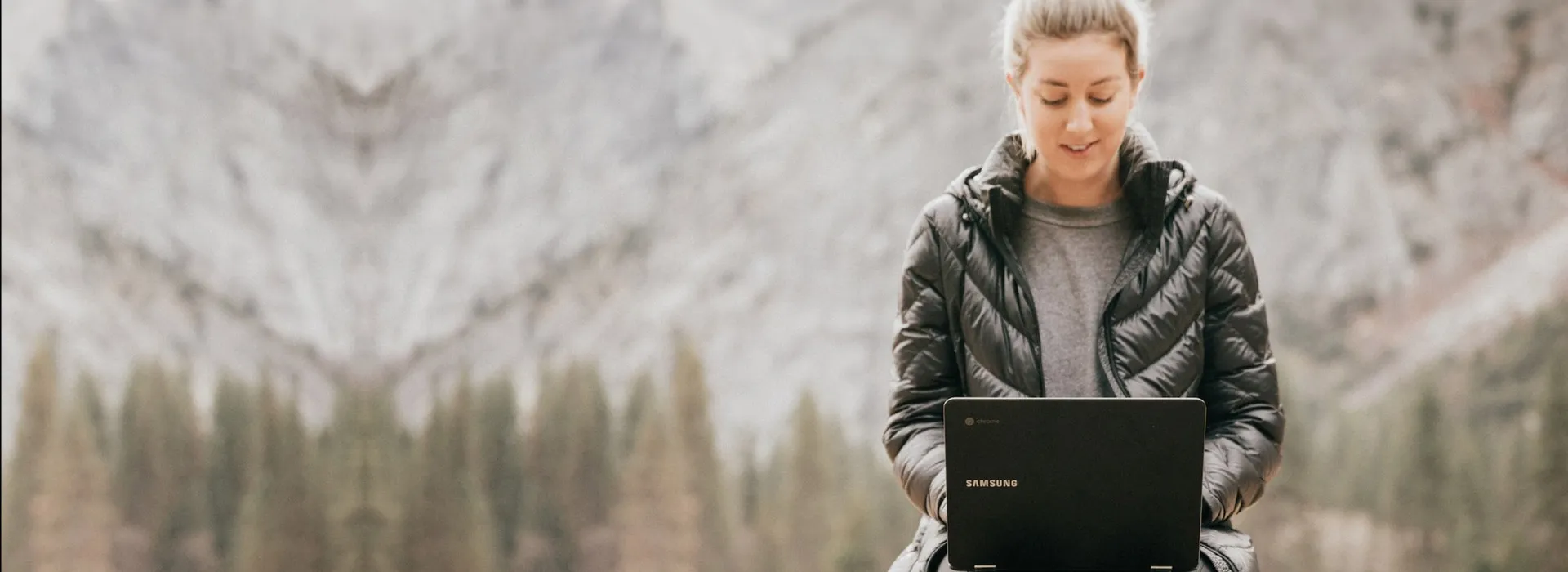 woman working on laptop in the middle of the mountains
